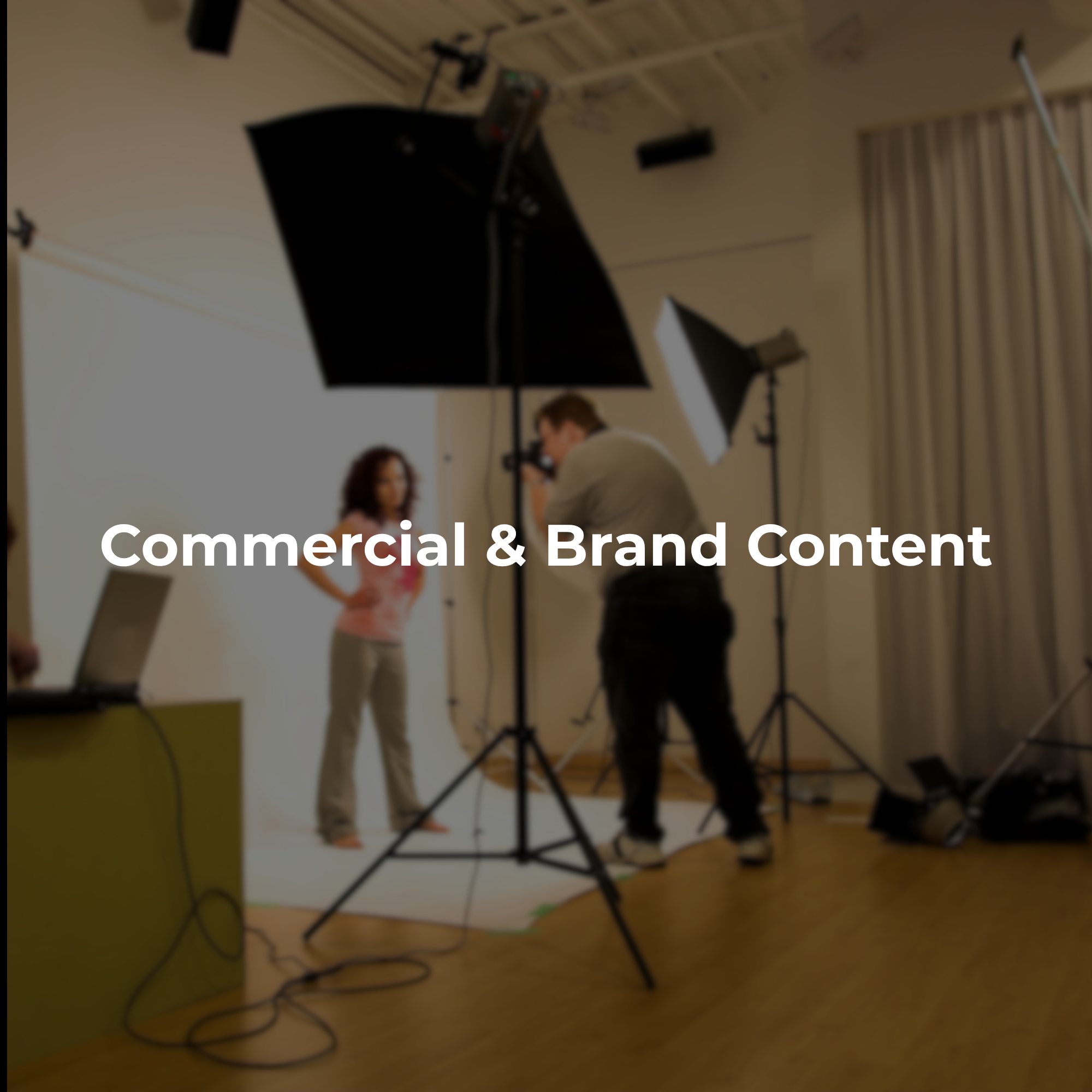 Commercial photography and video production setup with studio lighting, camera equipment, and a subject being photographed.