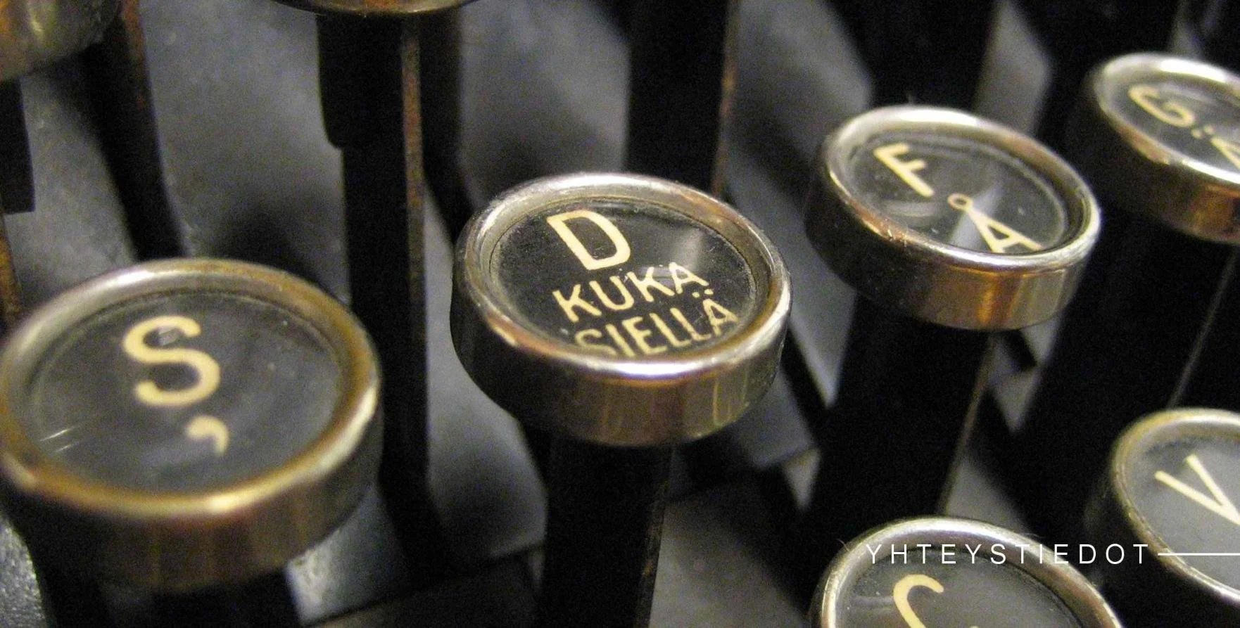 Perinteisen kirjoituskoneen nappuloita, joissa yhdessä lukee "kuka siellä".