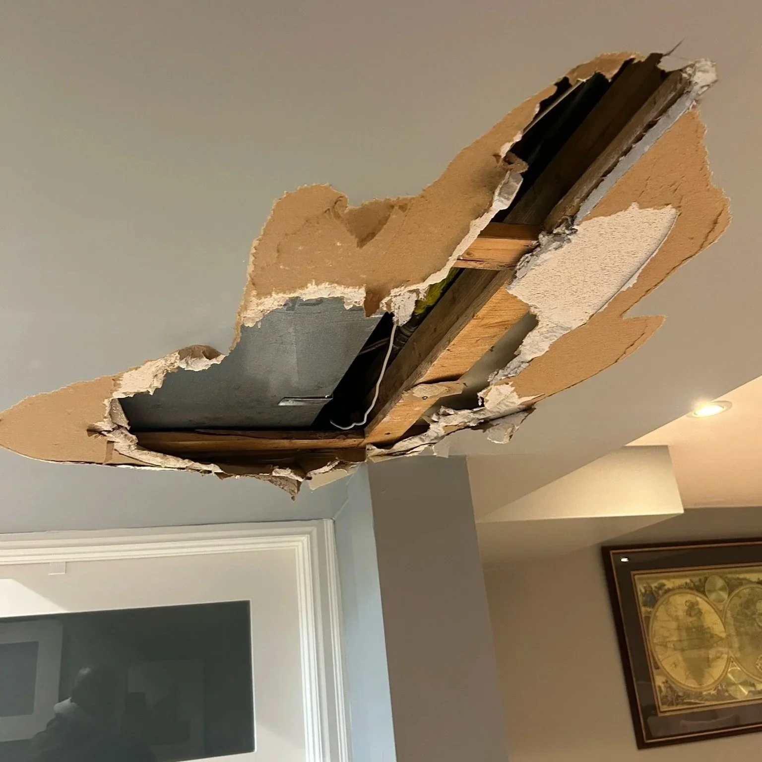 Ceiling damaged before repair, showing a large hole in the drywall in Etobicoke.