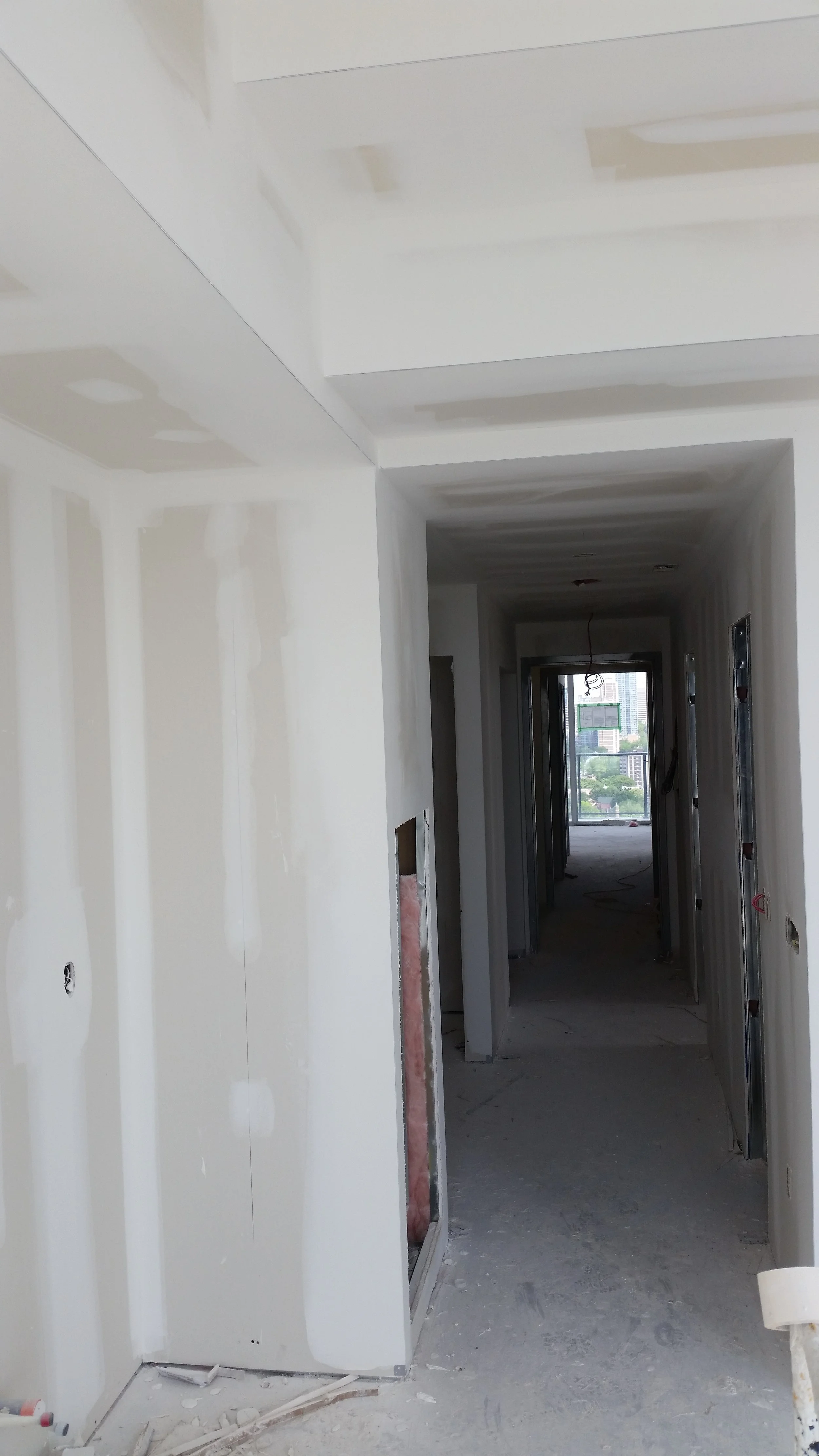 Hallway drywall installation and ceiling preparation during a custom home project in Toronto.