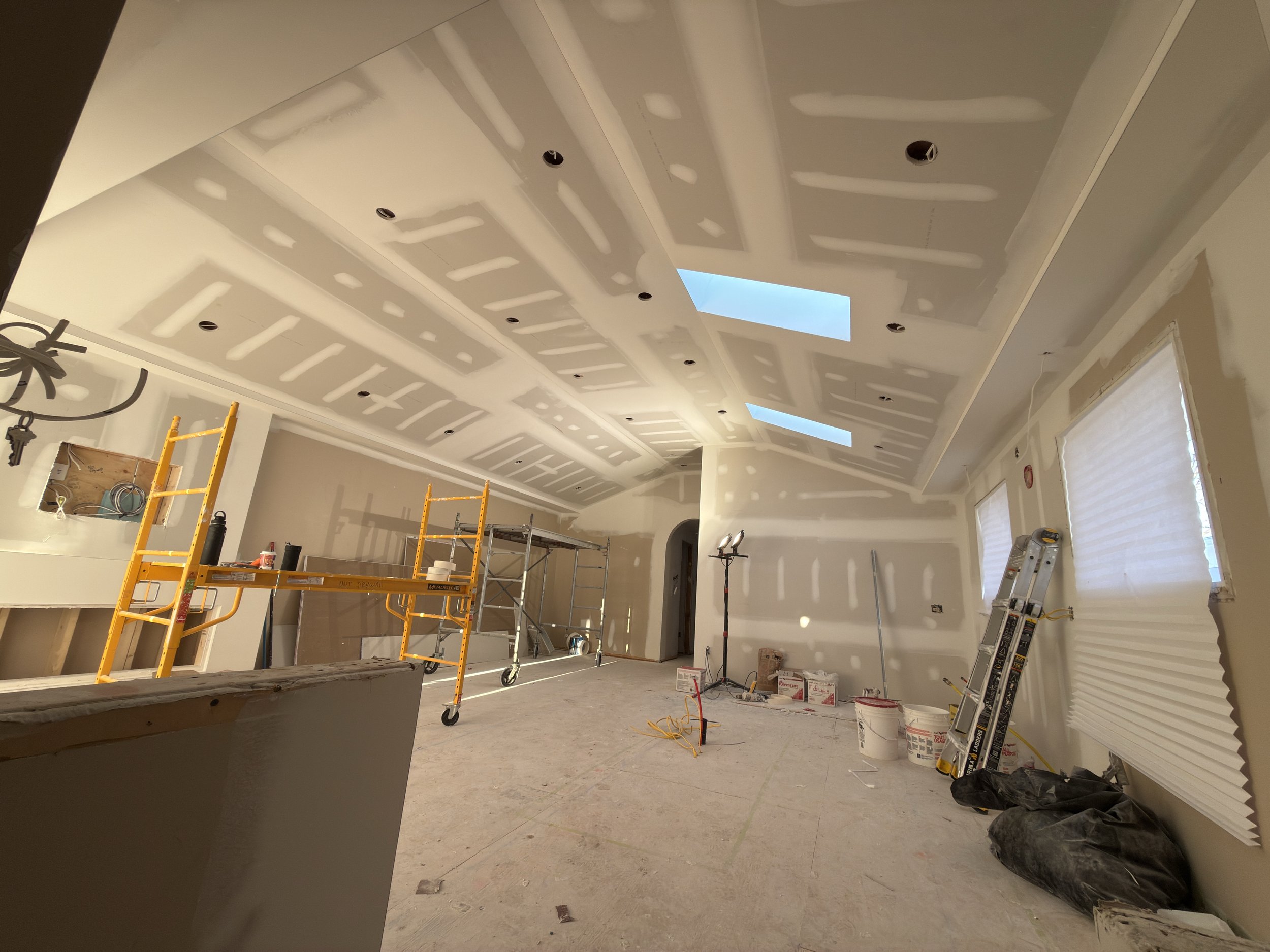 Main floor of the house with vaulted ceiling and pot lights drywalled and plastered ready to paint