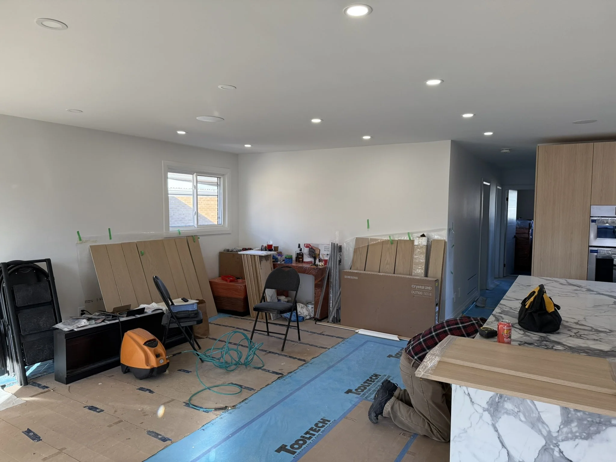 Living room under renovation with drywall installation done and joints taped.