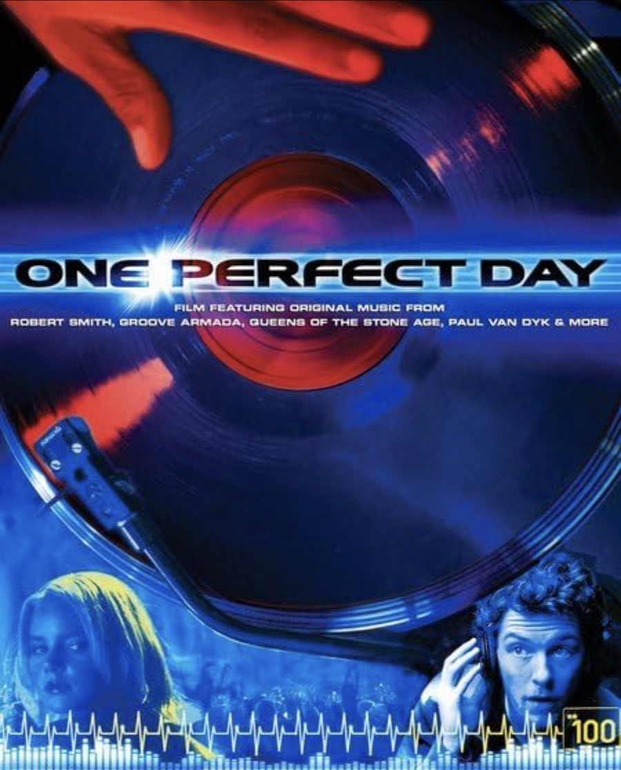 A promotional poster for a film titled 'One Perfect Day' featuring original music. The poster depicts a vinyl record spinning on a turntable with a red hand reaching towards it. There are images of a woman with blonde hair and a man with curly hair l