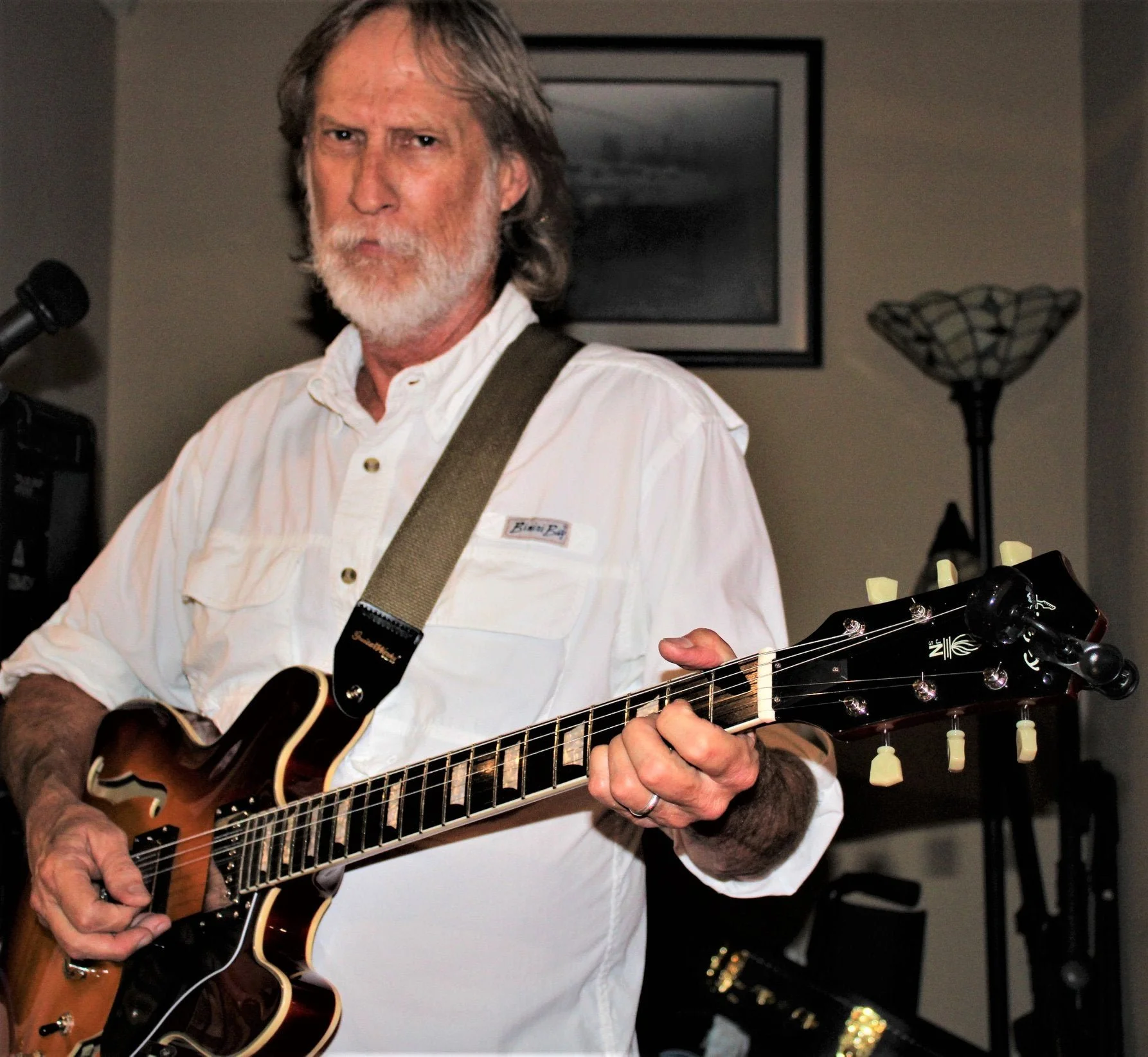 An older man with gray hair and a beard playing an electric guitar at Dandridge Brewery.