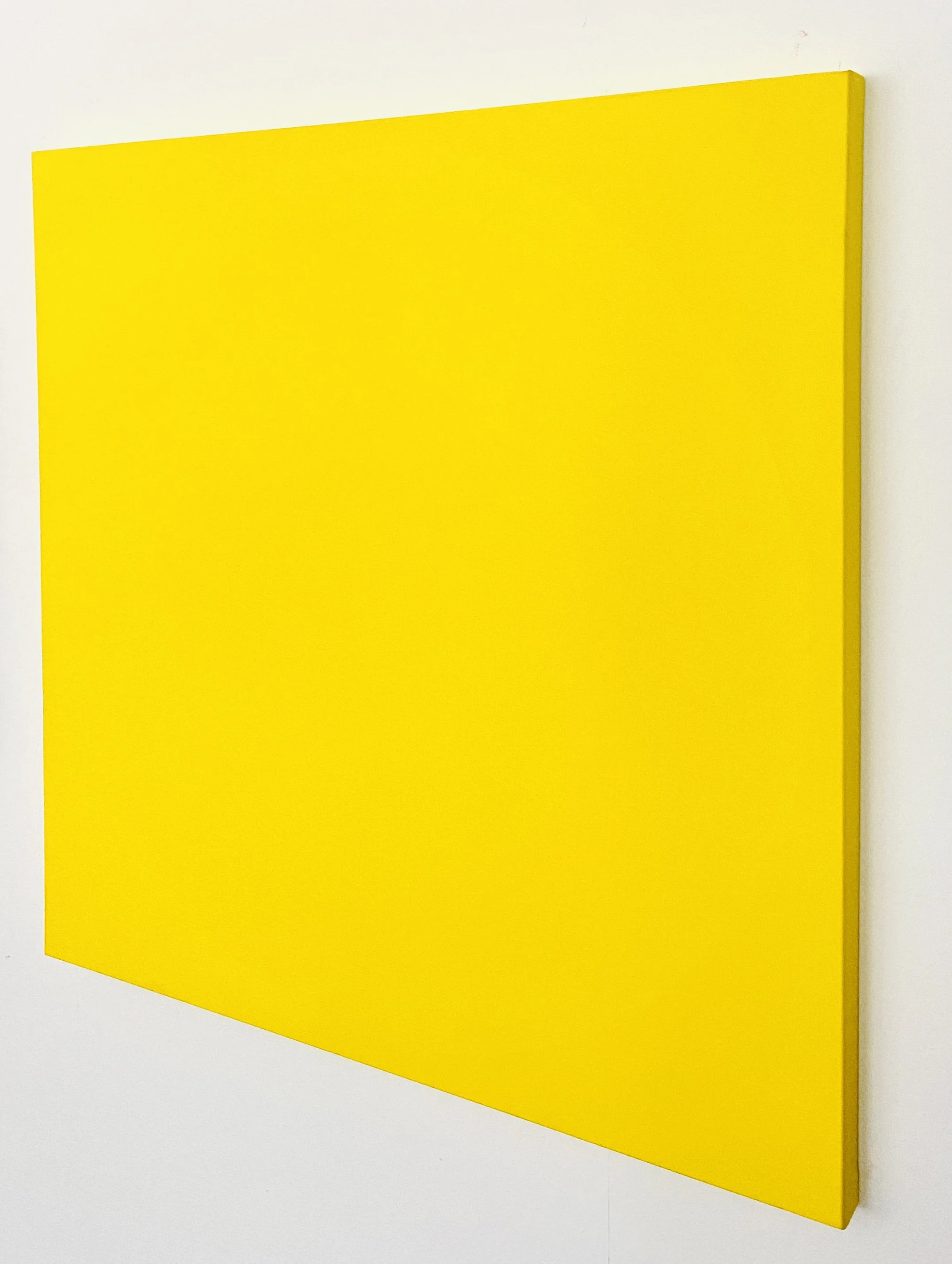 A bright yellow rectangular panel attached to a plain white wall.
