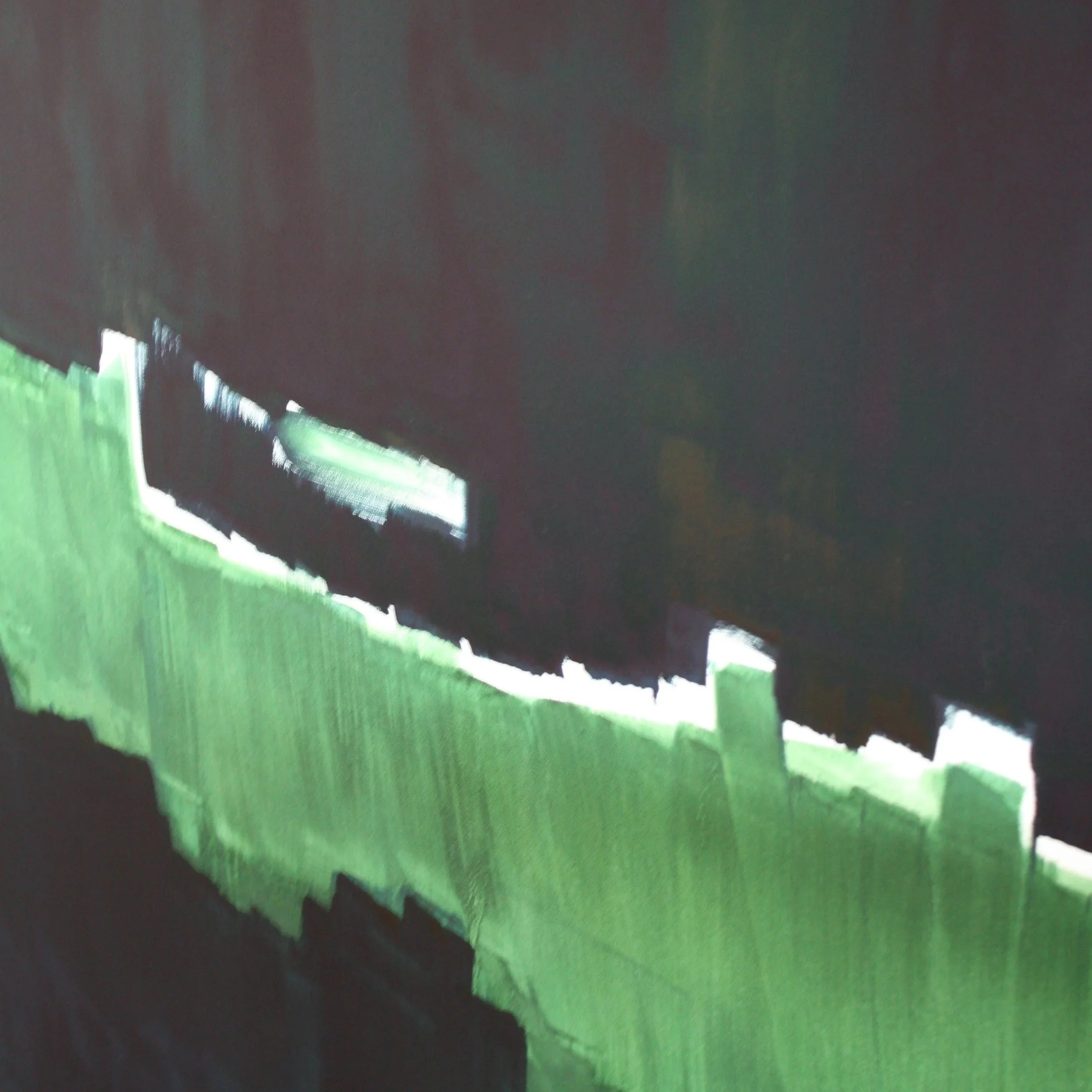 Close-up view of a torn, irregular-edged paper with a black, green, and white background.