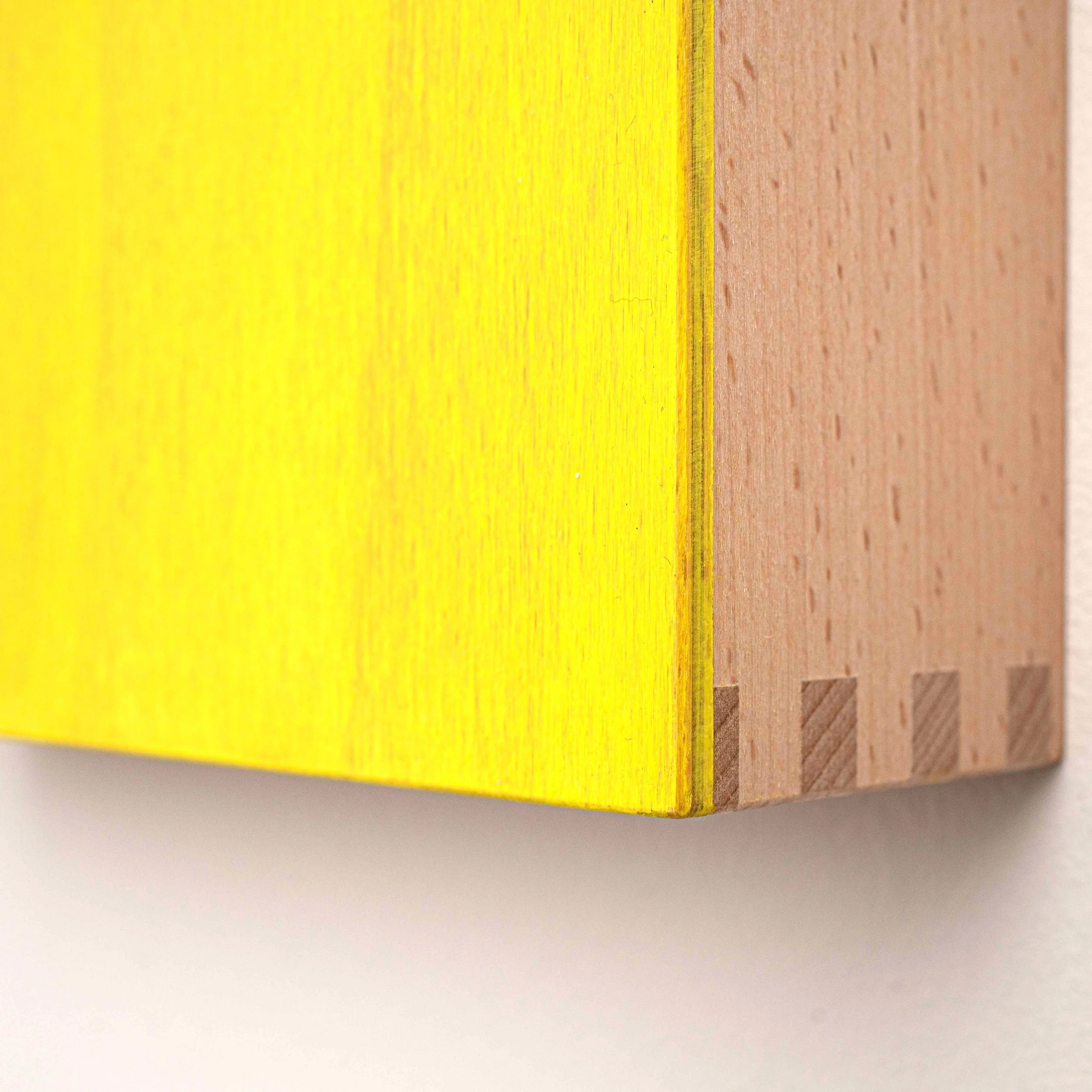 Close-up of a textured yellow, orange, and light brown cardboard edge on a white surface.