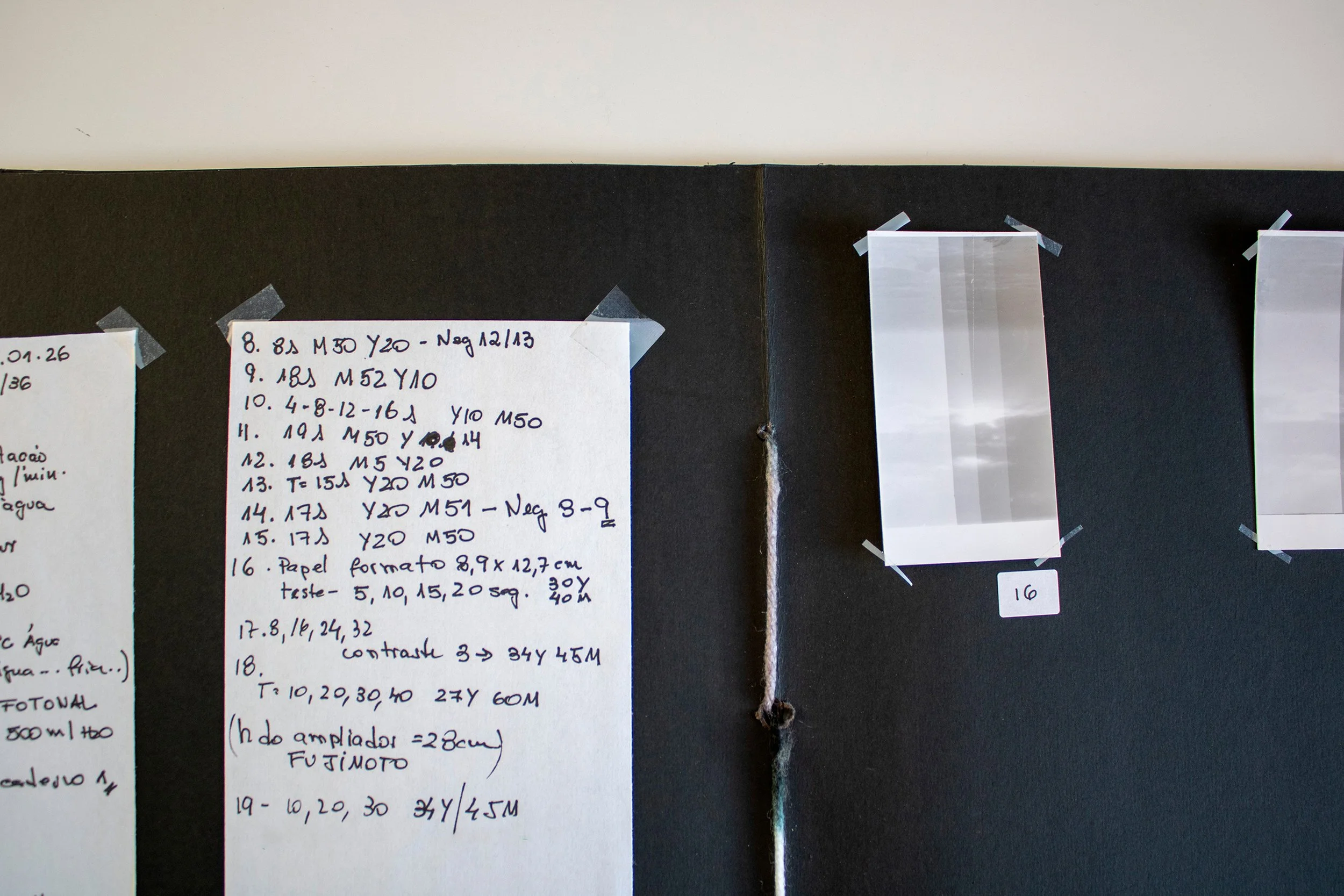 Detalhe de página de um dos cadernos de artista com anotações de exposição, filtros e tempos de ampliação em fotografia analógica.