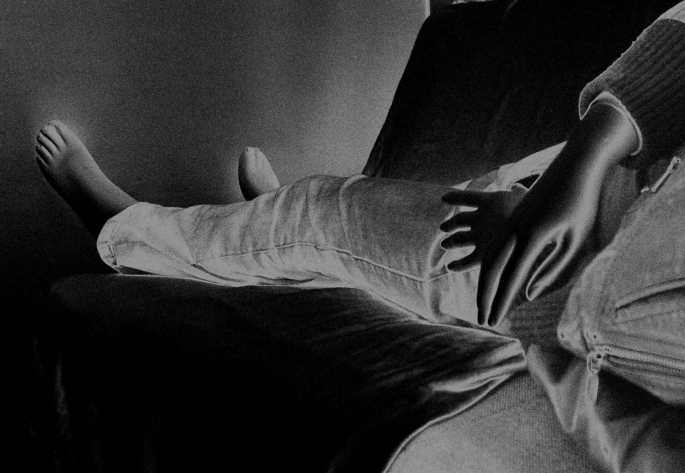 Fotografia digital em preto e branco, integrante da Série Digital 1, de Sandra Unglert Fernandes, mostrando uma pessoa reclinada com as mãos sobre o corpo, em composição com inversão tonal.