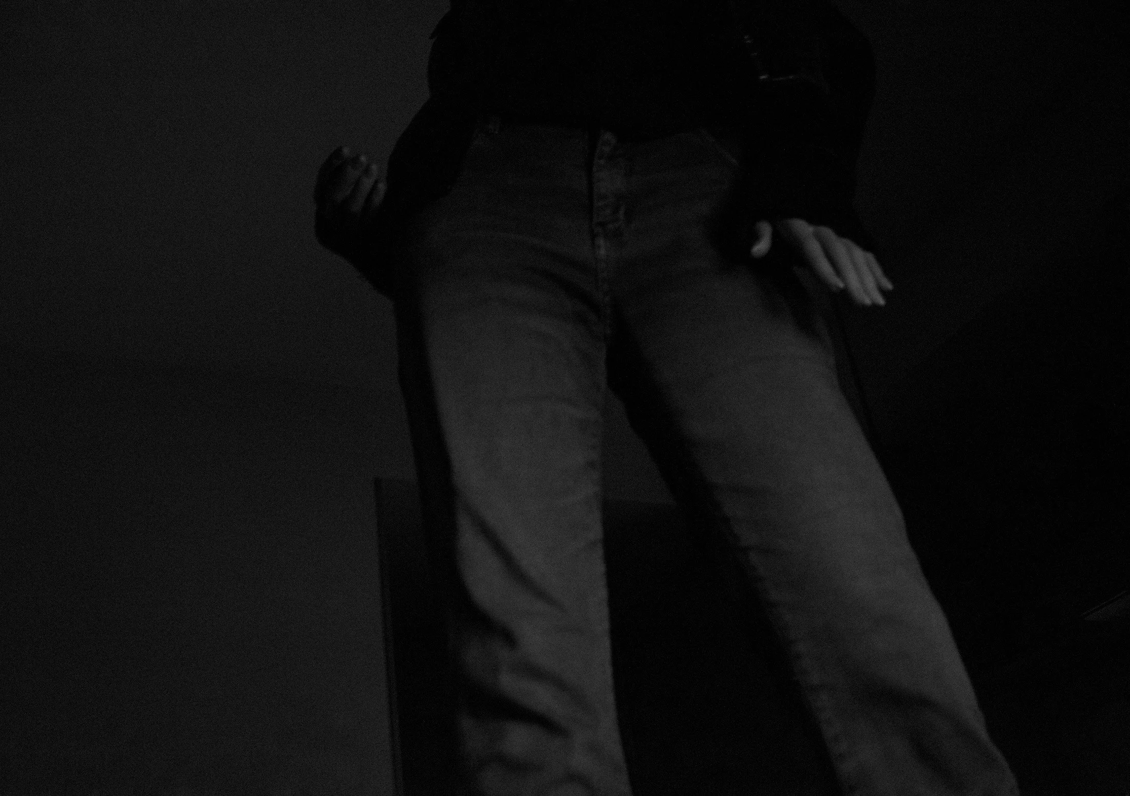 Fotografia digital em preto e branco, integrante da Série Digital 1, de Sandra Unglert Fernandes, mostrando uma pessoa parcialmente enquadrada diante de um monitor em ambiente escuro.