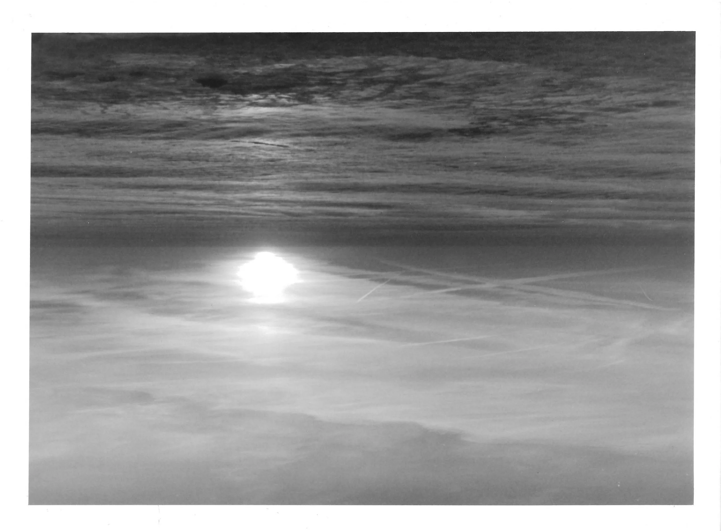 Fotografia analógica em preto e branco, integrante da Série 3, de Sandra Unglert Fernandes, apresentando foco de luz refletido sobre uma superfície, contrastando com texturas escuras e camadas luminosas.