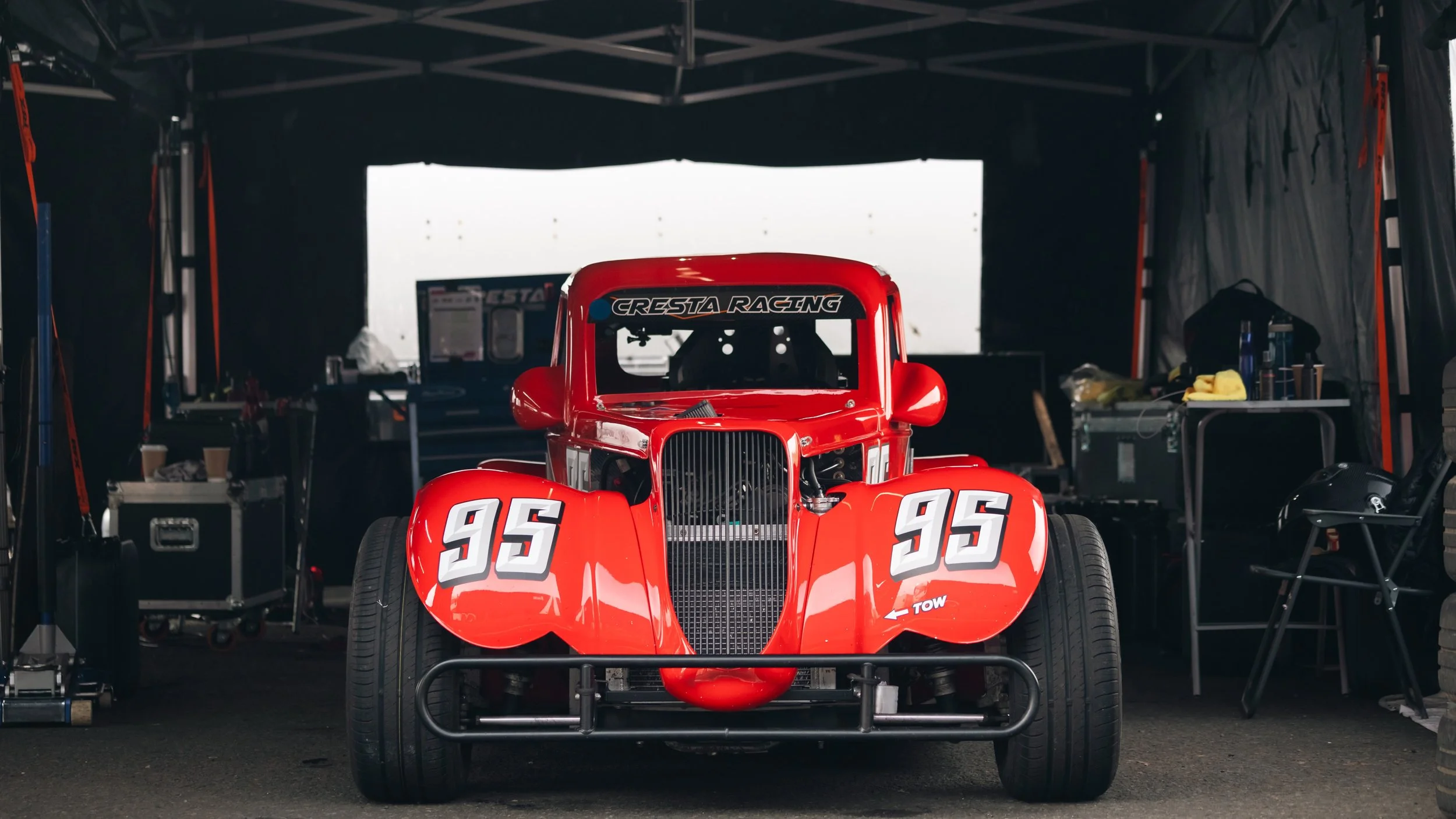 Red Legends car in a tent garage at knockhill