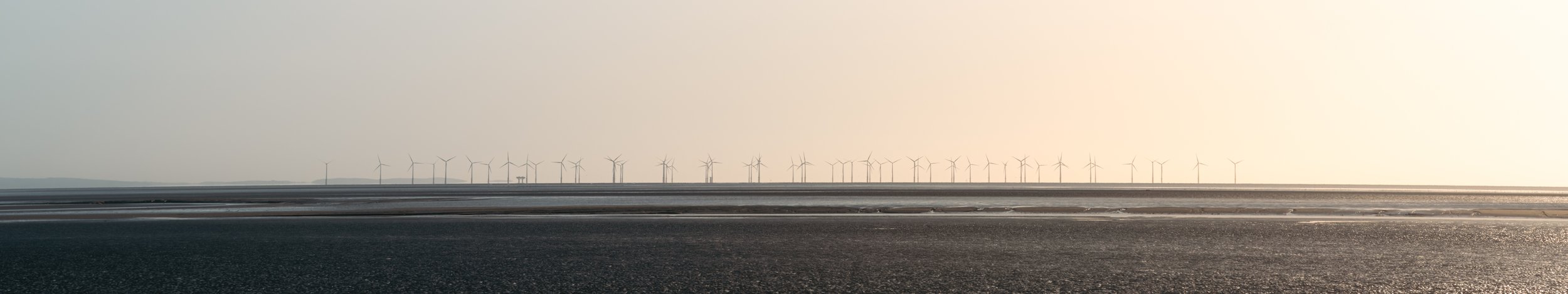 Wind turbines on the horizon over beach
