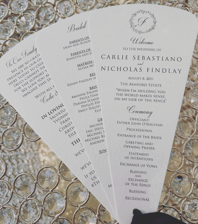 Wedding ceremony program with a wreath logo, name of the couple, date, and ceremony details, laid on a bed of rhinestones.