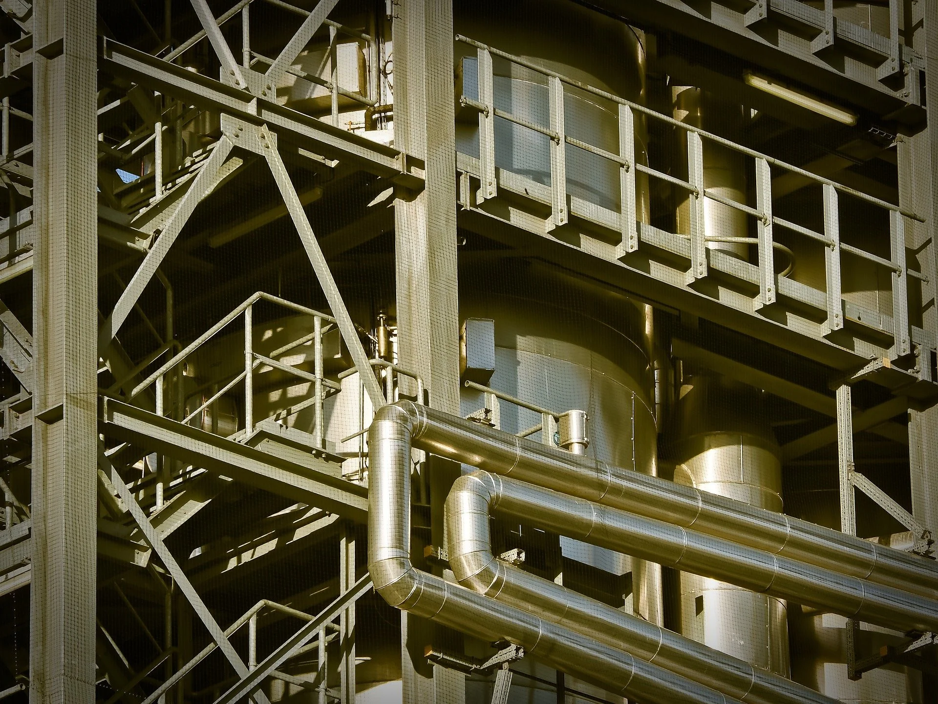 Close-up view of an industrial metal structure with pipes and scaffolding.