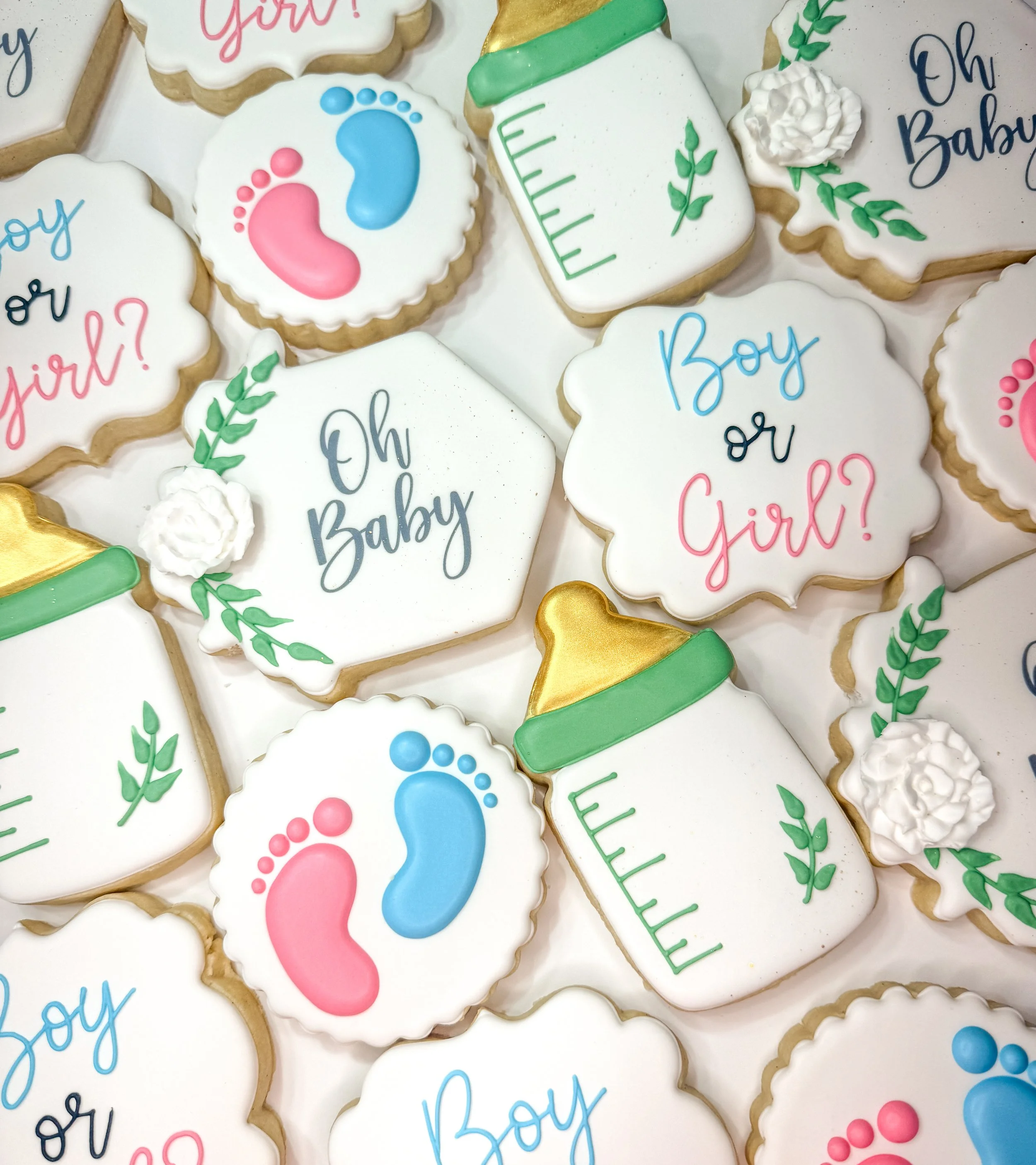 Decorated cookies with baby-themed designs and messages, including pacifiers, bottles, and the phrases 'Boy or Girl?'