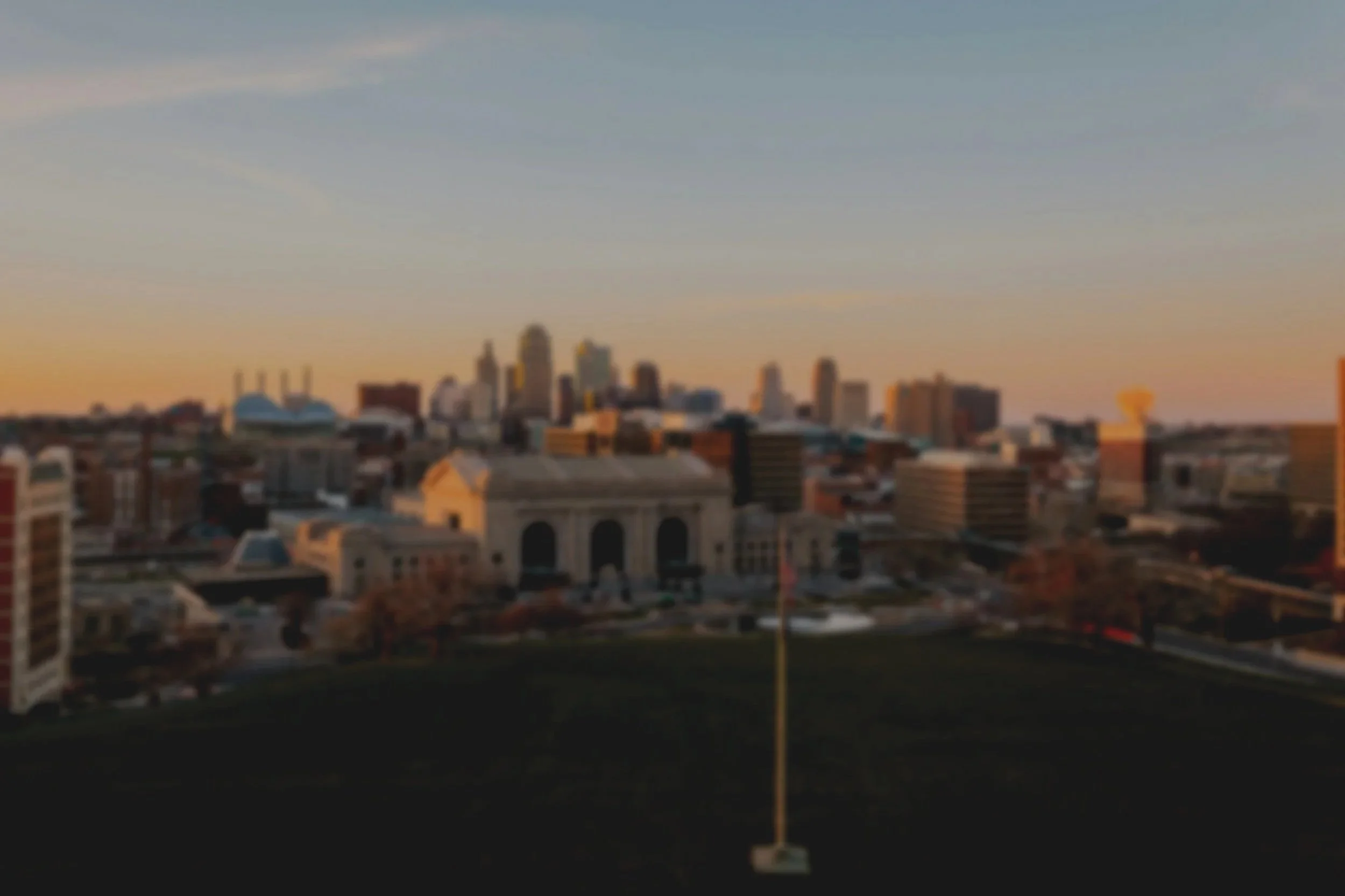 Vista de la ciudad al atardecer con edificios altos y cielo despejado.