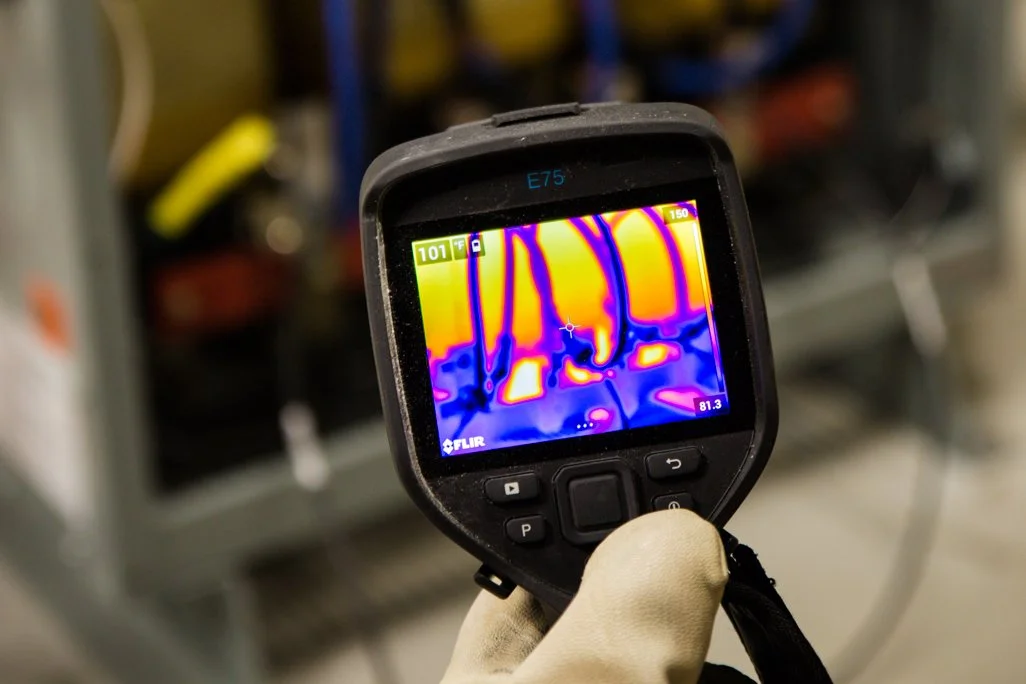 Thermal imaging camera displaying temperature variations of electrical wires or components.