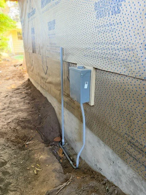 New electrical disconnect and feeder conduit installed on the exterior wall for a detached home office in Tigard, Oregon