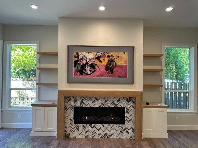 Layered recessed and floating-shelf lighting around a living room fireplace remodel