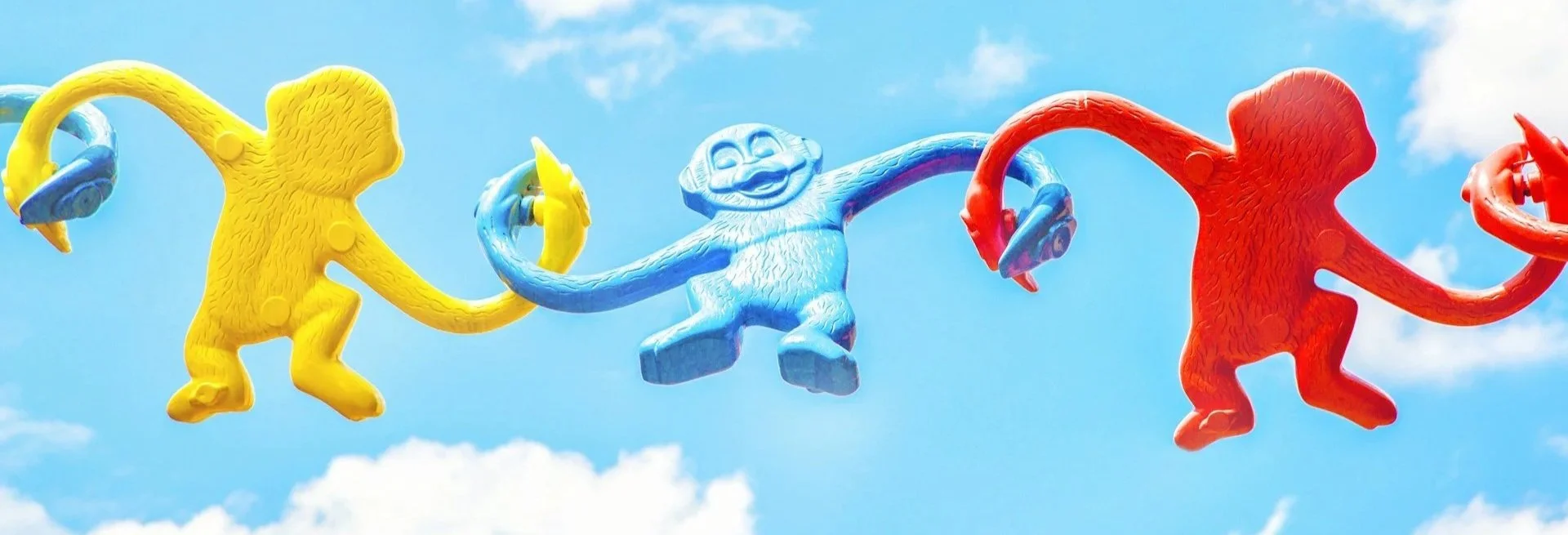 Colorful linked toy monkeys representing connected a commuinty built through clean electrical energy from Nexus Electrical Group