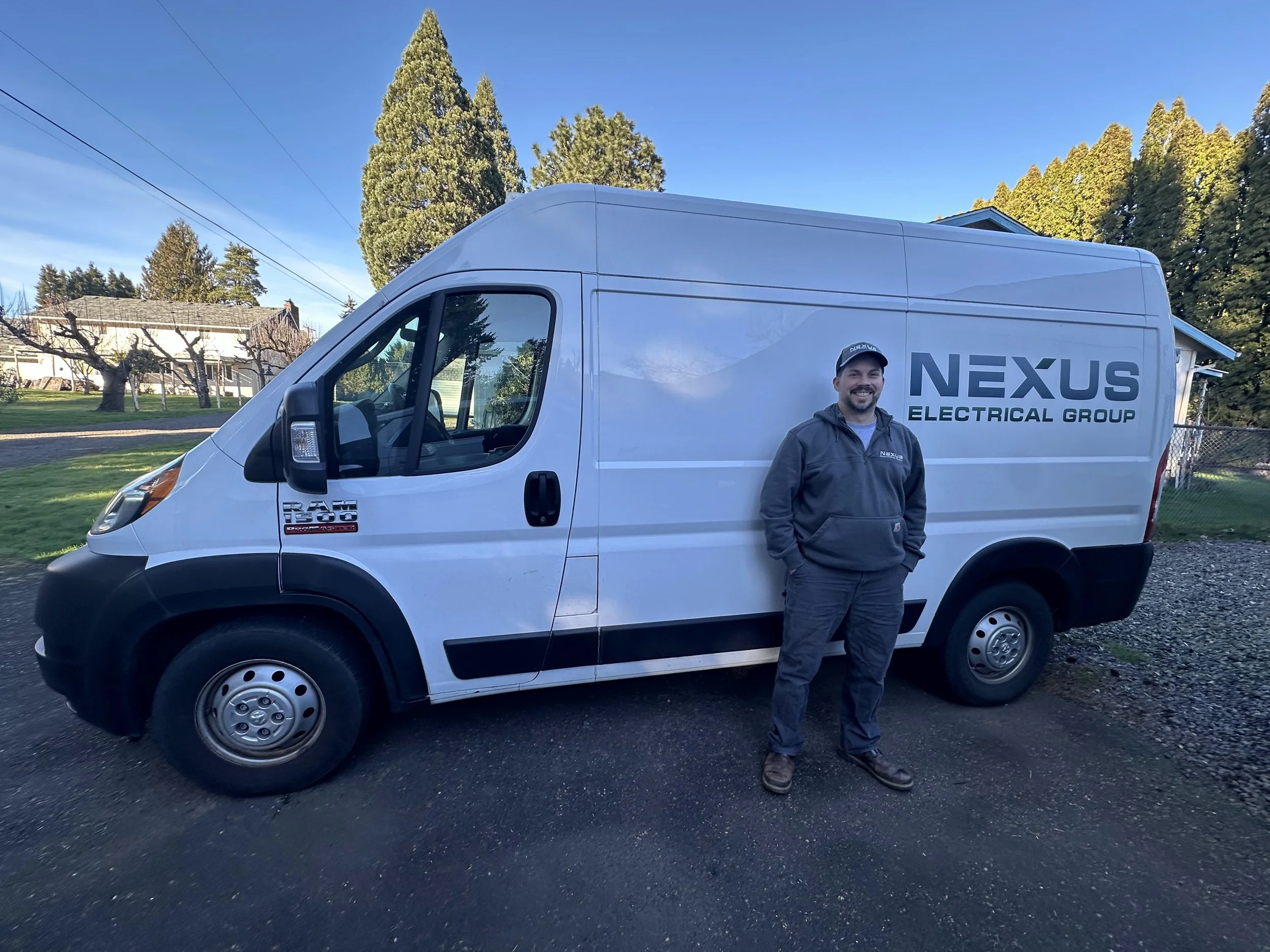 Nexus Electrical Group electrician standing beside the company work van in the Portland metro