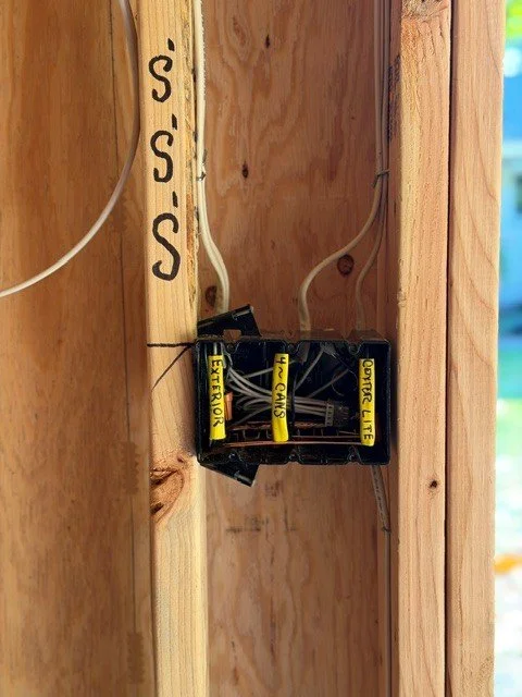 Labeled junction box for exterior, can lights, and office lighting circuits inside a detached home office wall in Tigard, Oregon