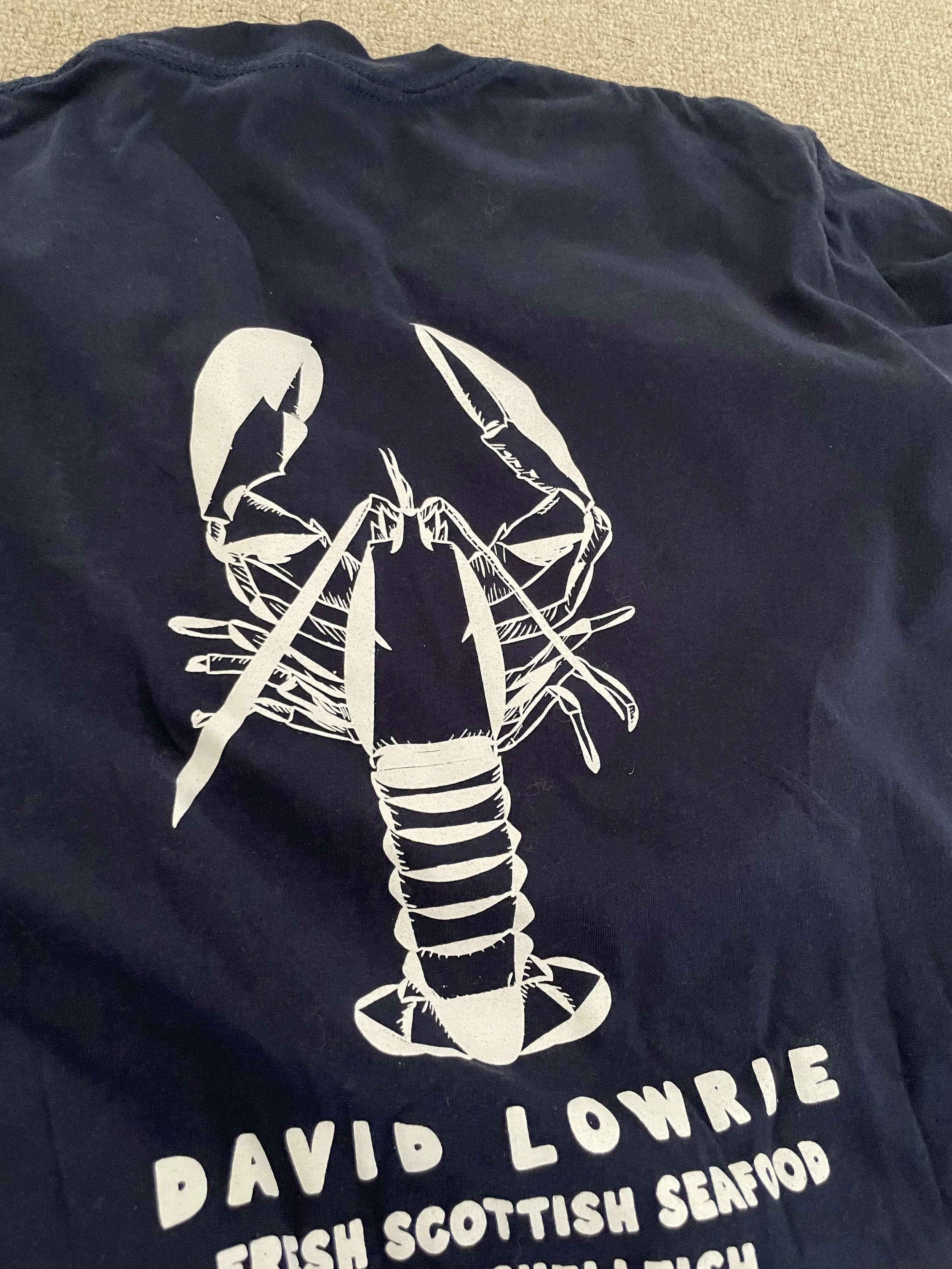 T-shirt featuring an illustration of a lobster with text mentioning 'Davis Lobster' and 'Scottish Seafood'.