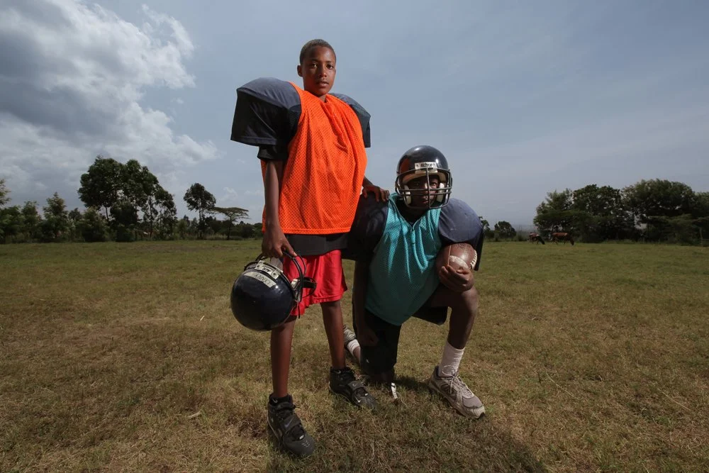 Two youth players pose for a portrait in donated gear during an American football clinic hosted by the Fellowship of Christian Athletes (FCA), Wednesday, Jan. 4, 2012, near Nakuru, Kenya.