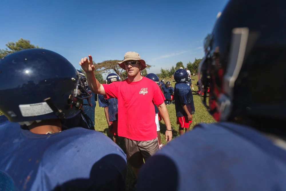 Tallahassee Lincoln High assistant coach Kyle Eastridge addresses youth players from inside a team huddle during a Fellowship of Christian Athletes (FCA) football clinic at Mountain Park Academy, Wednesday, Jan. 4, 2012, in Nakuru, Kenya.