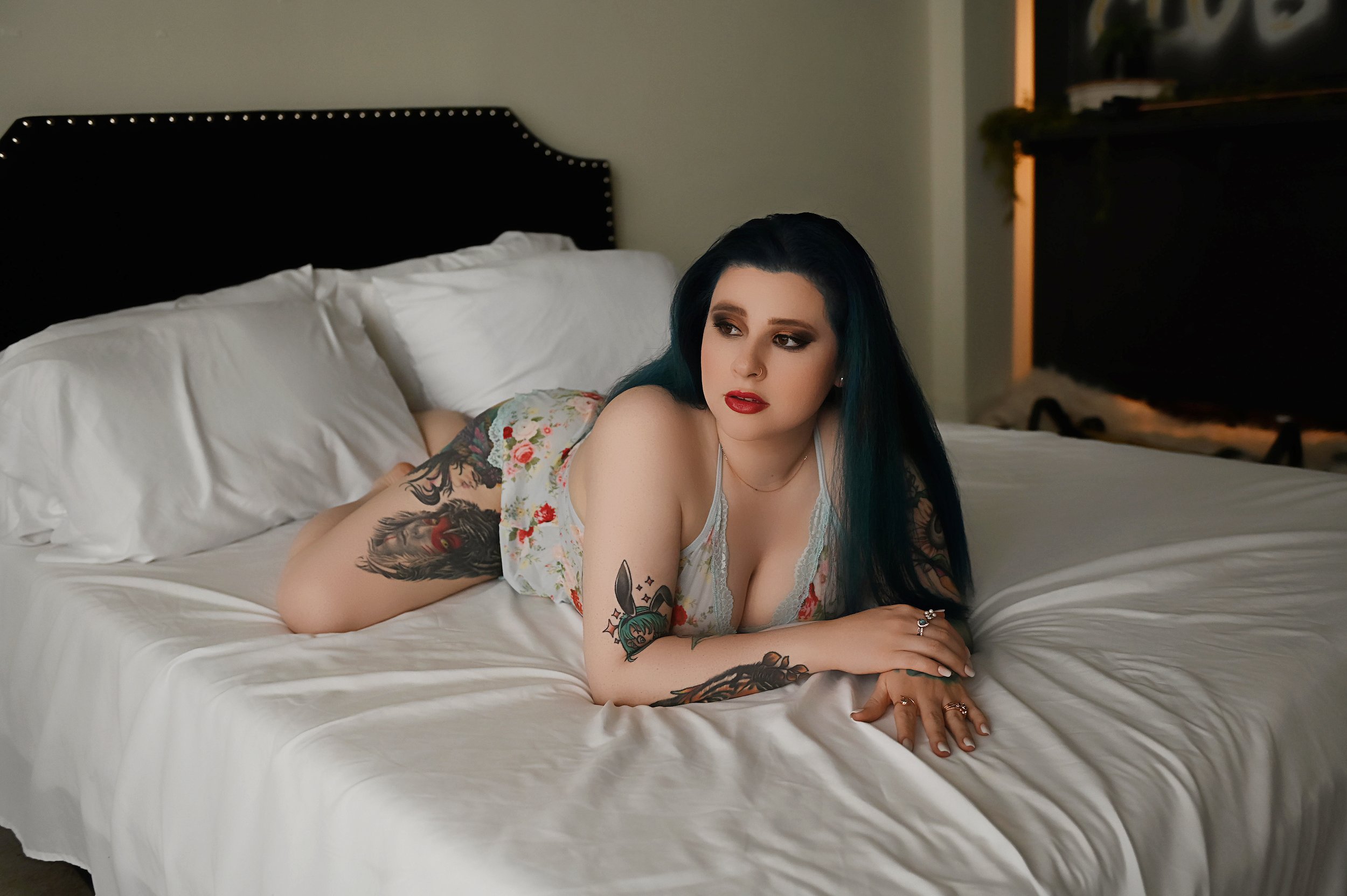 Woman in floral lingerie posing on a white bed during a Shreveport boudoir photography session