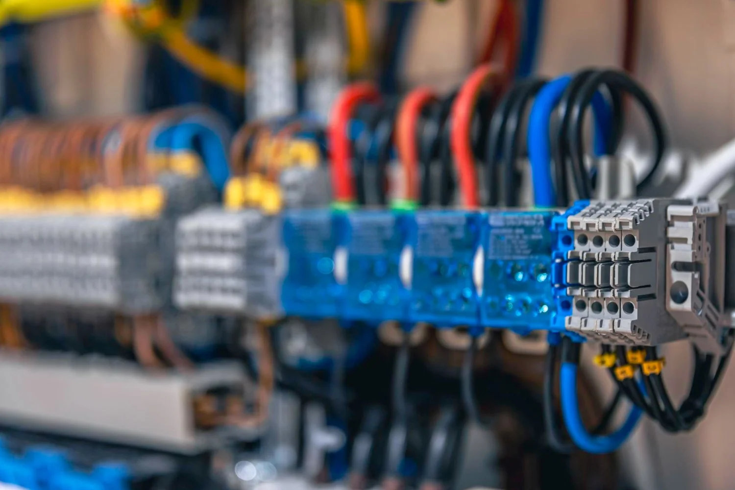 Close-up view of electrical control panel with colorful wiring and circuit components.