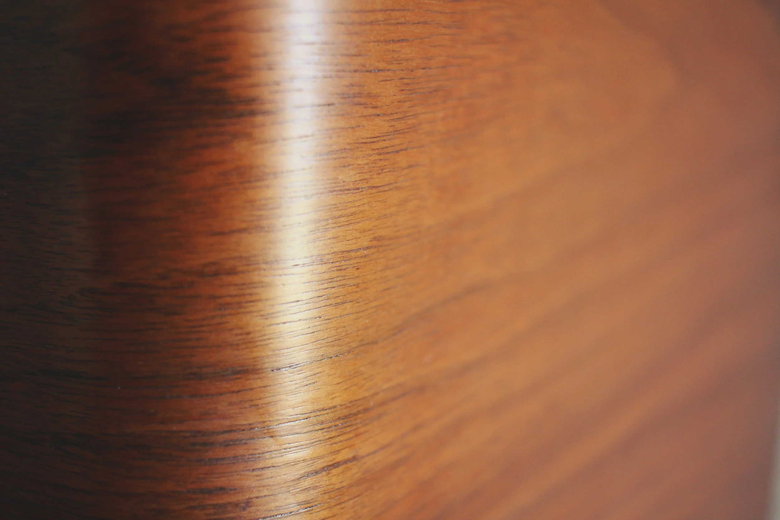Close-up of a wooden surface with a smooth finish and visible grain patterns.