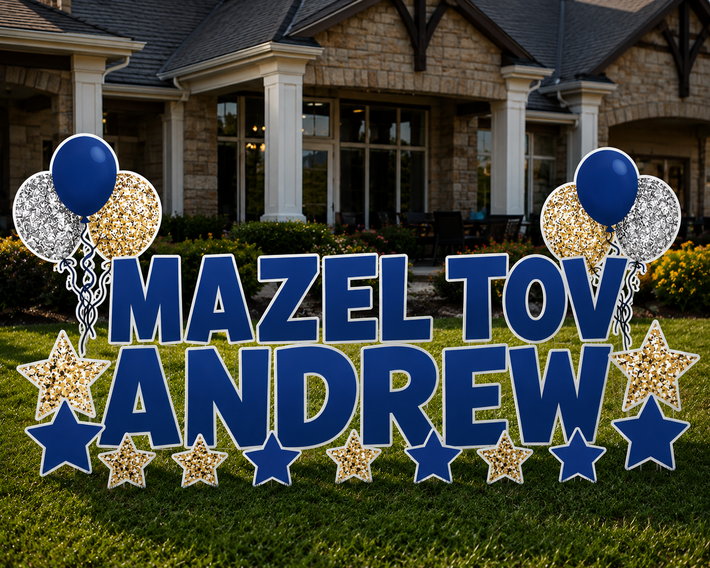 Personalized outdoor decoration with large blue letters spelling 'Mazeltov Andrew,' surrounded by balloons and star-shaped ornaments, placed on a green lawn in front of a house.