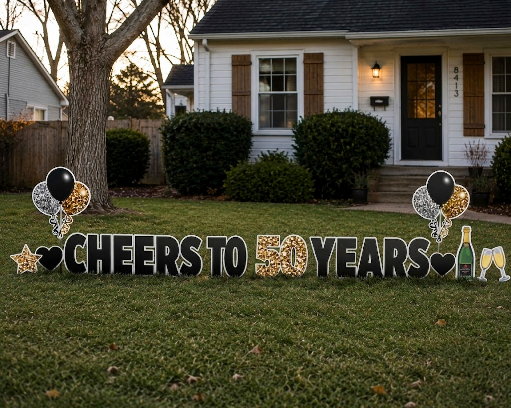 Outdoor yard sign celebrating 50 years, with cheerful decorations including balloons, champagne bottle and glasses, and celebratory text in front of a house.