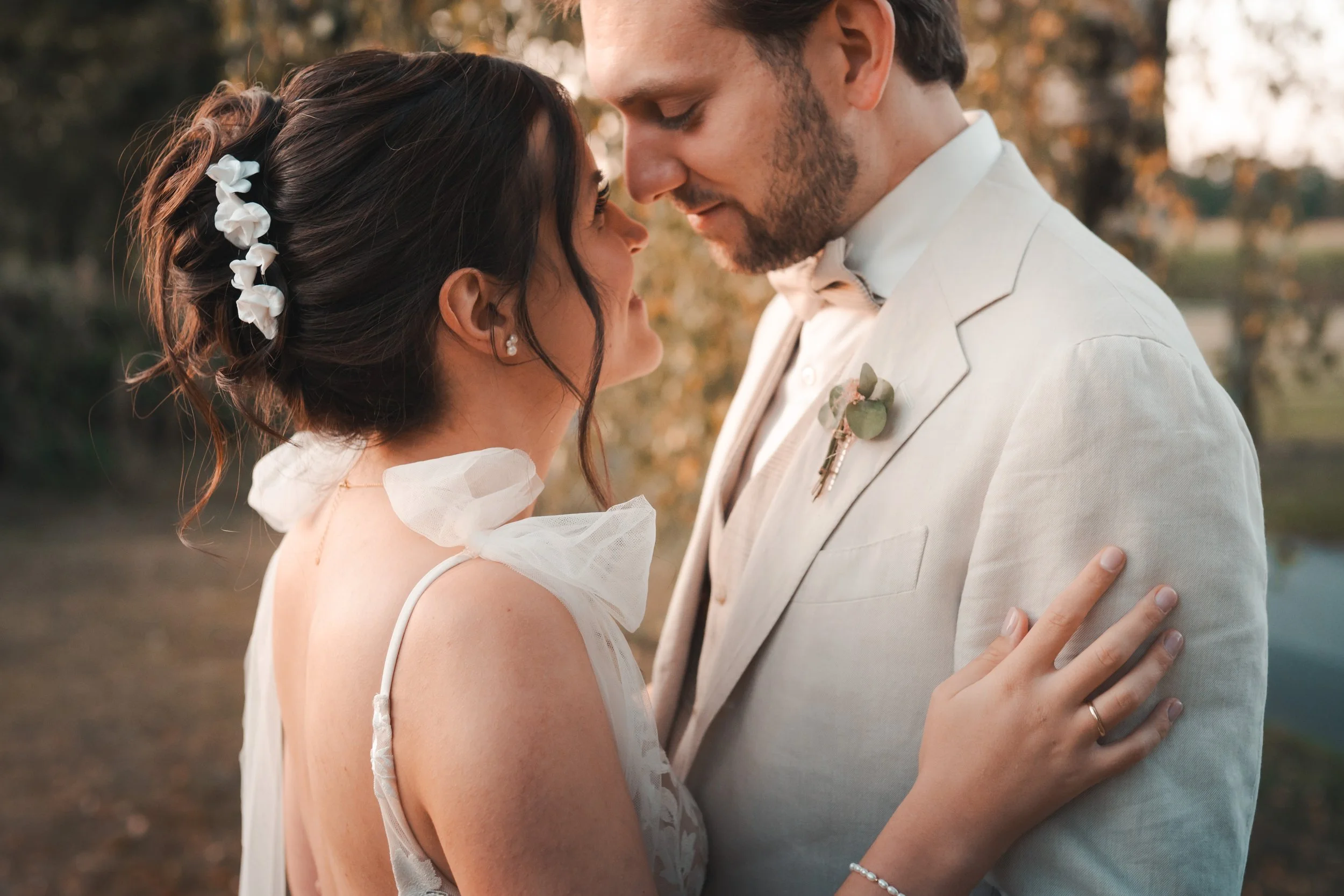 Ein Hochzeitspaar bei einer Hochzeit im Freien, die sich nahekommen und sich liebevoll umarmen. Videobegleitung Hochzeitsfilm