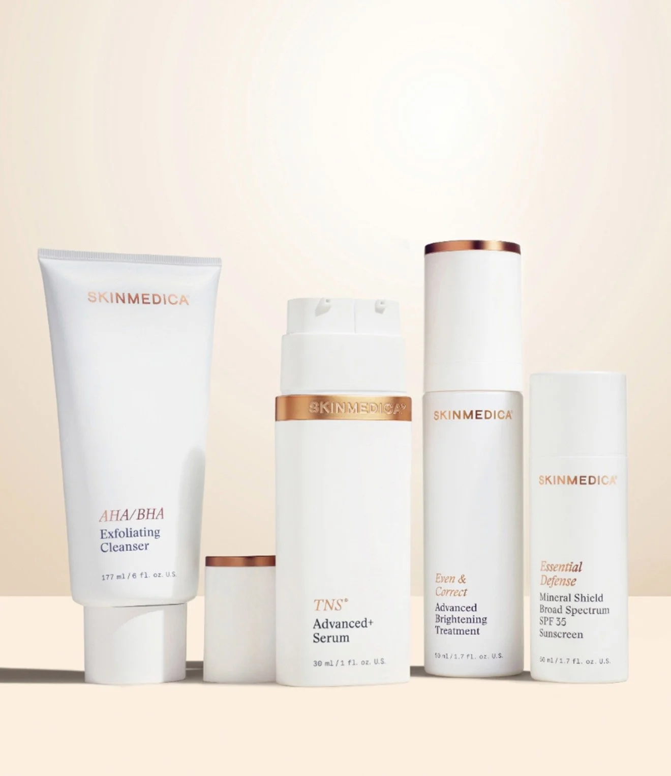 A collection of skincare products from the brand SKINMEDICA, including exfoliating cleanser, advanced plus serum, brightening treatment, and broad spectrum sunscreen, arranged on a neutral background.