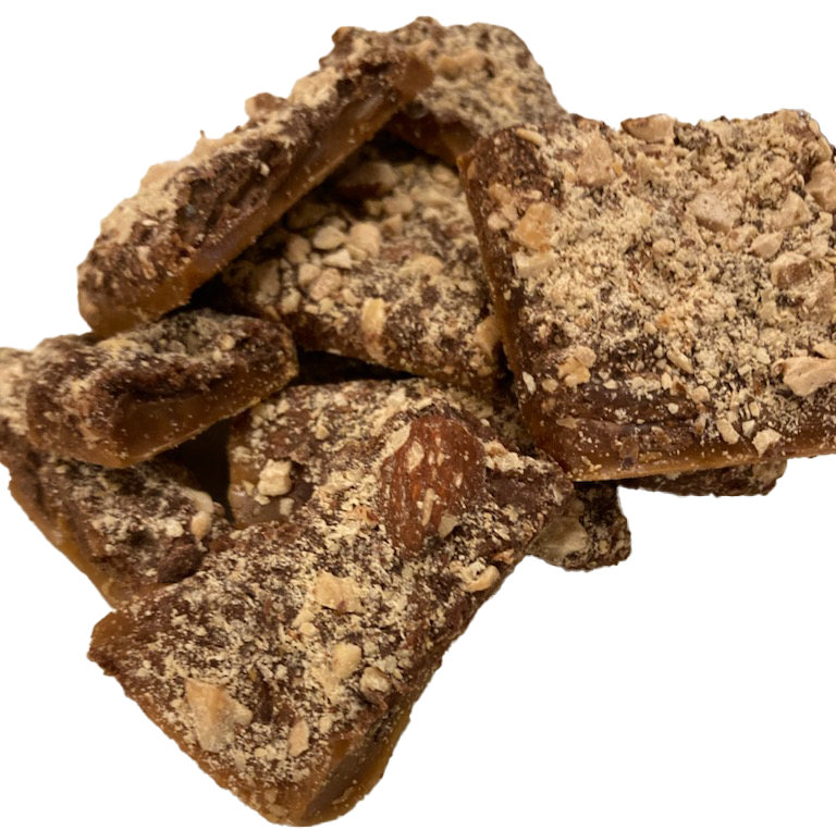 Close-up view of three chocolate candy bars covered with crushed nuts.