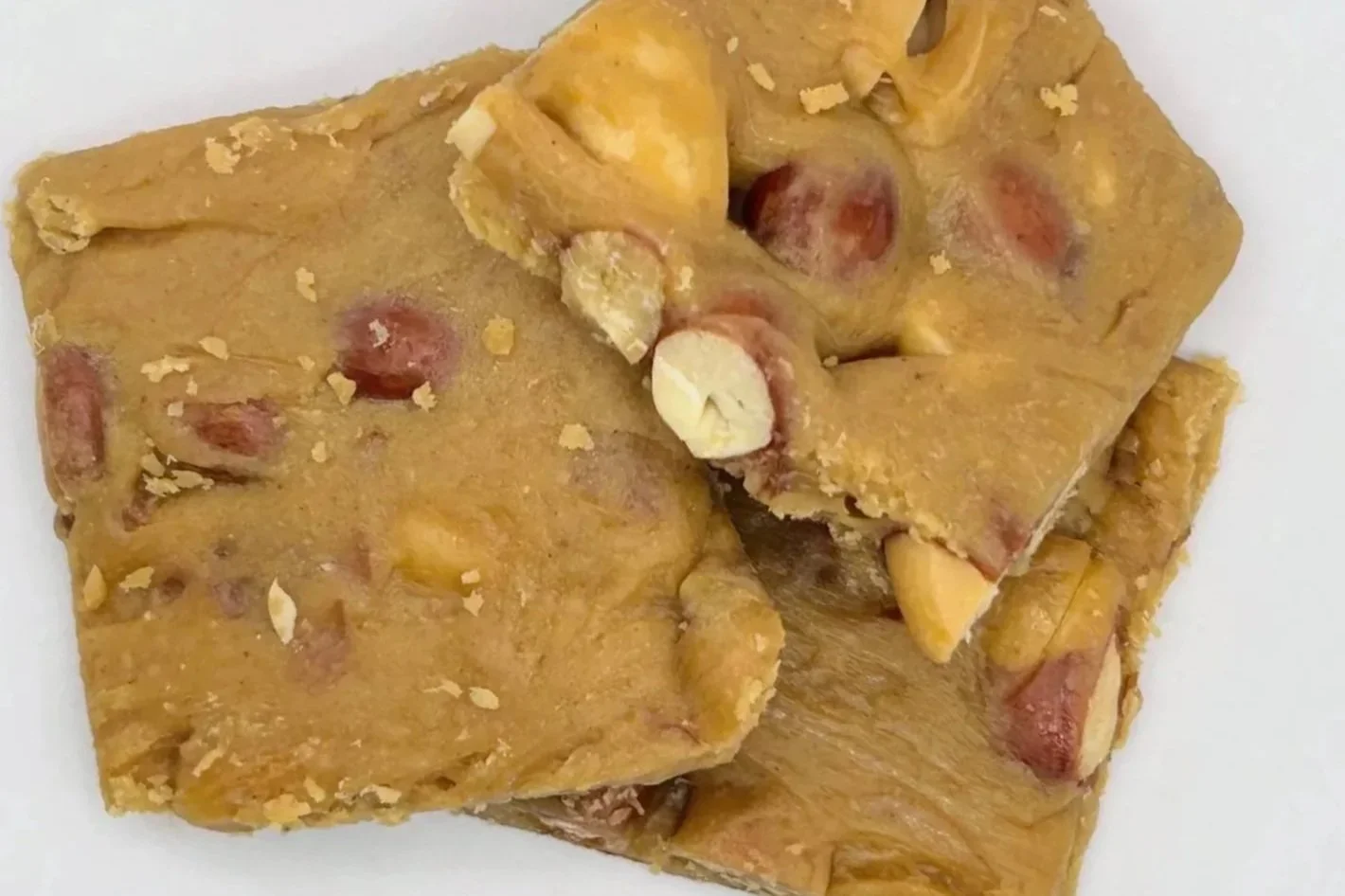 Close-up of peanut brittle candy with peanut pieces and a caramelized texture.