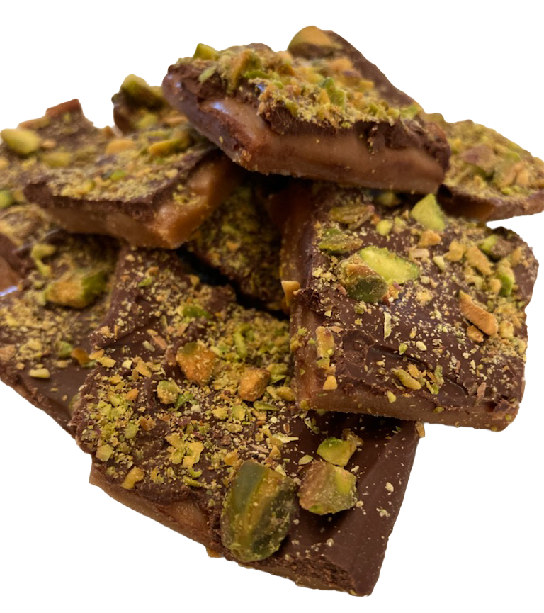 Pieces of chocolate almond bark topped with chopped pistachios.