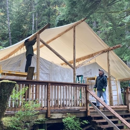 Mtn side contractors building outside exterior glamping tents for a remote wilderness lodge in British Columbia
