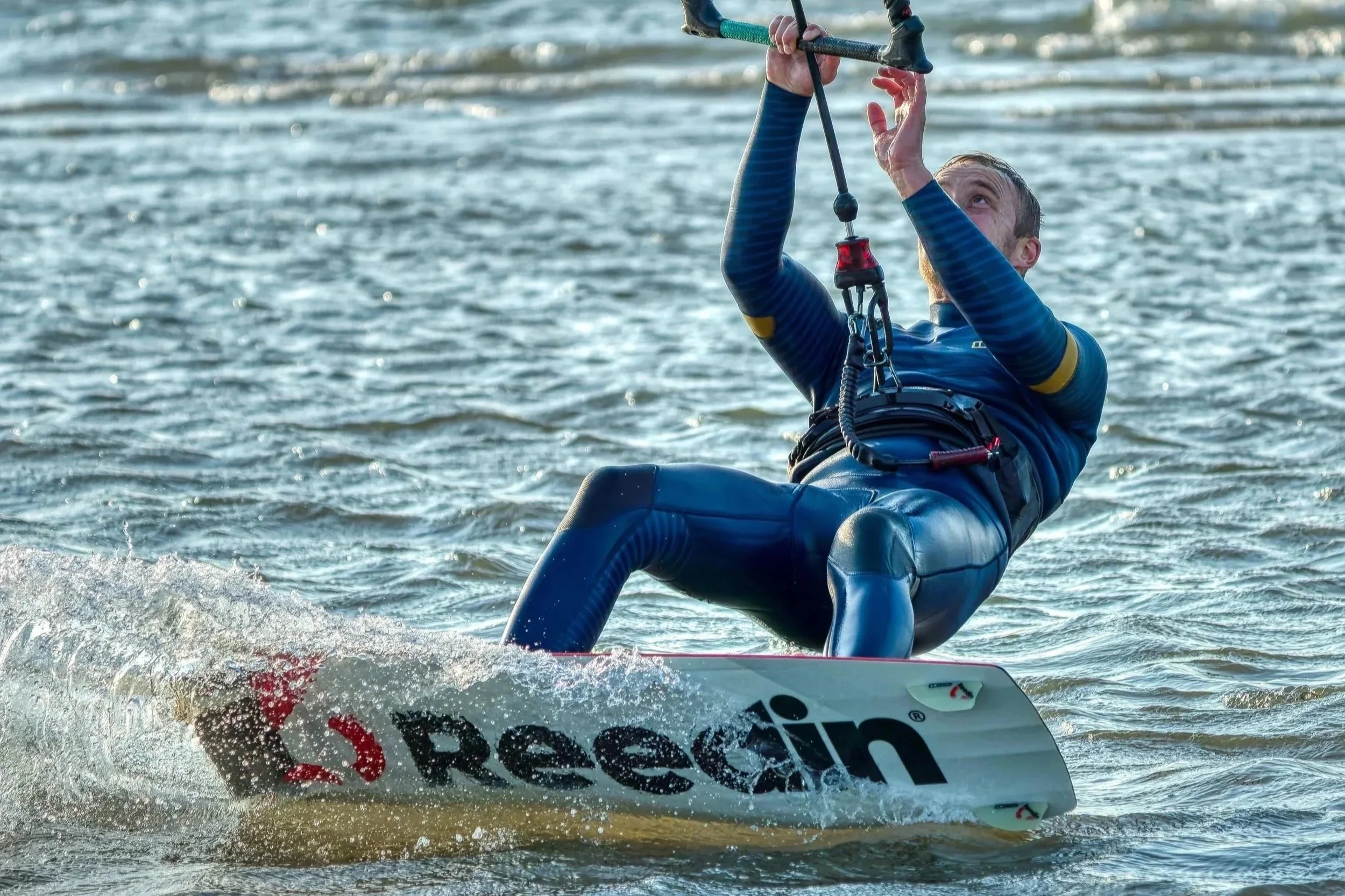 Een persoon in watersportkleding die zich vasthoudt aan een waterski om op het water te glijden.