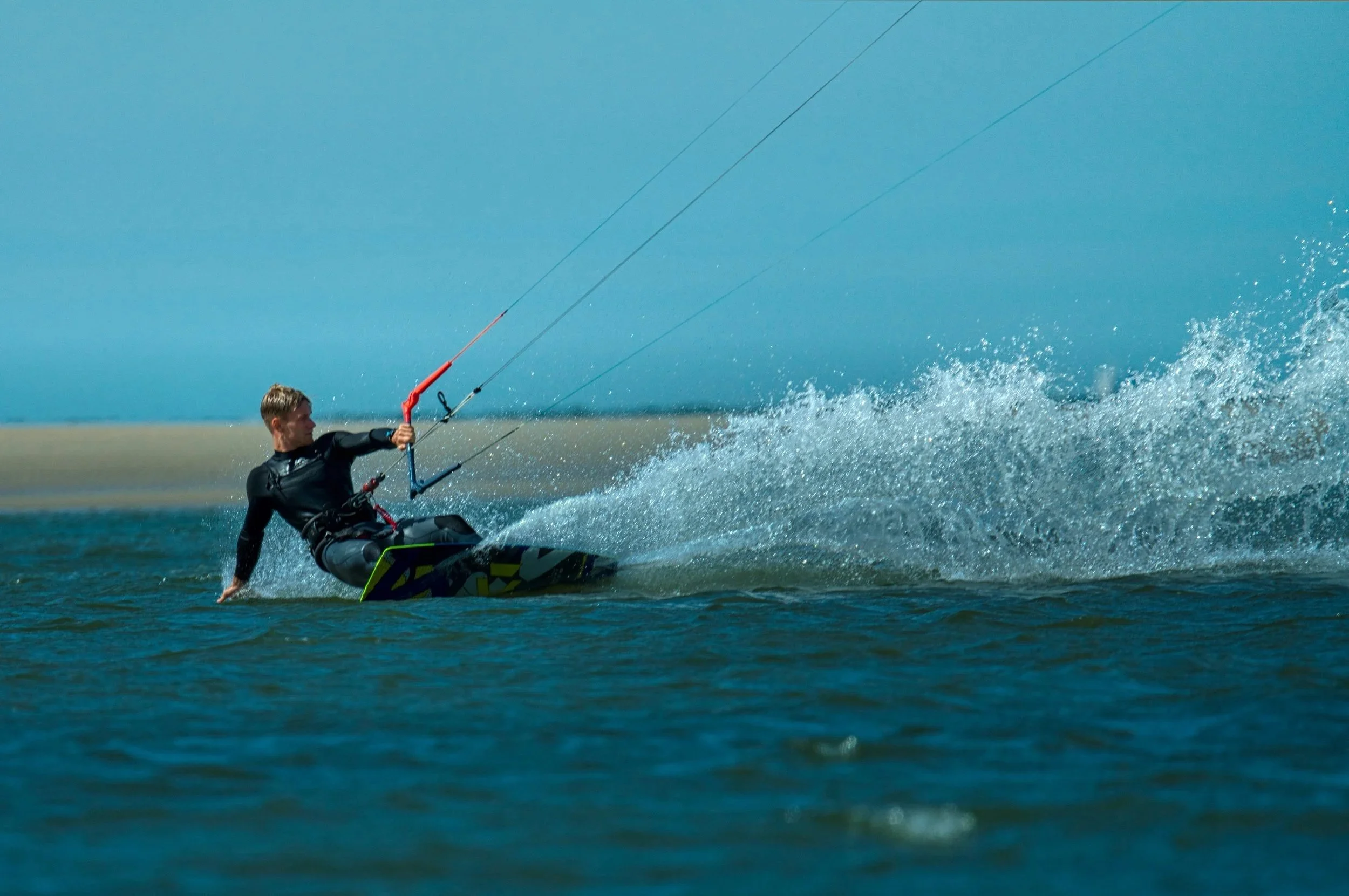 Persoon die kitesurft op zee tijdens zonnige dag.