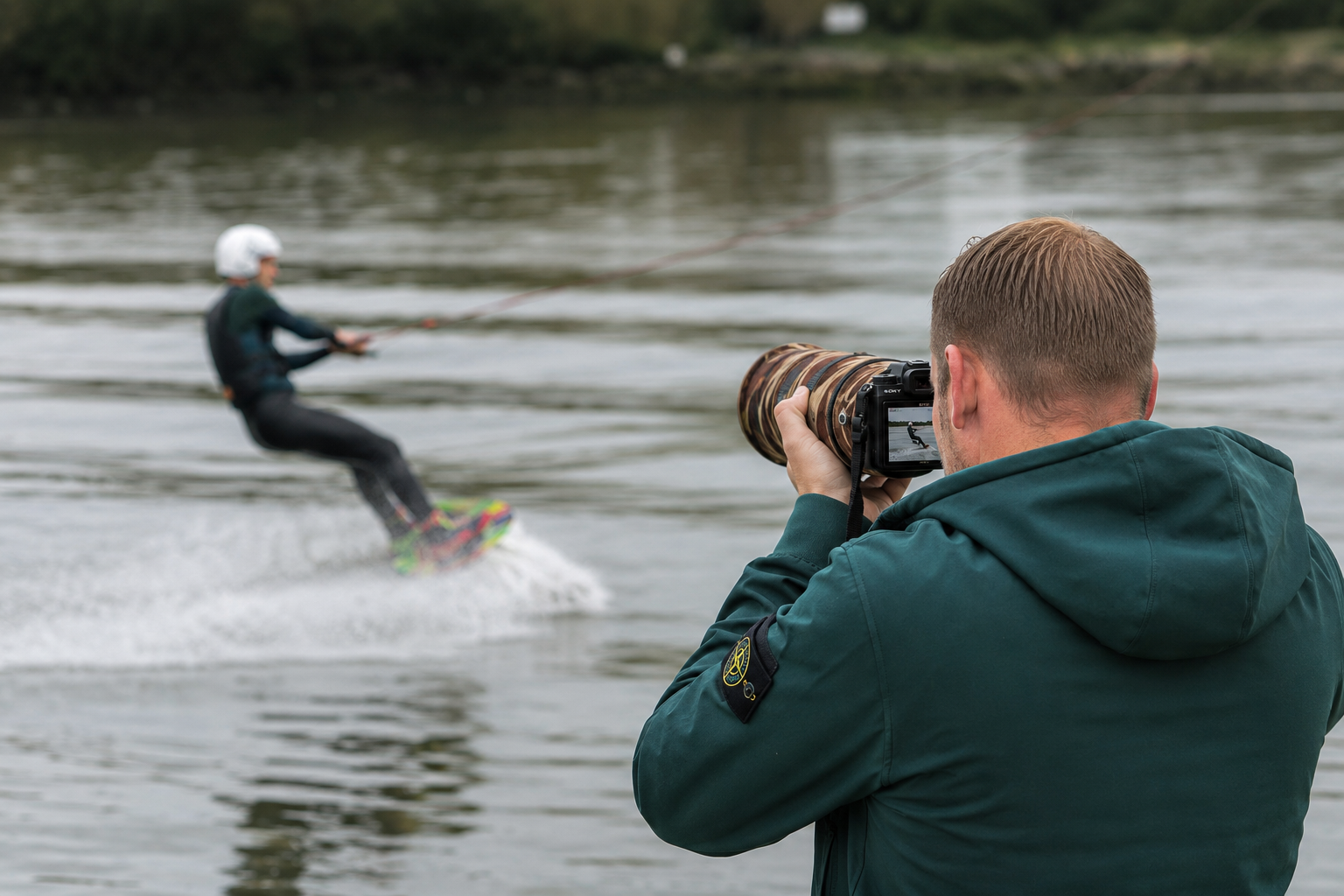 Vrouw die waterskiën op een meer, gefotografeerd door een man met een camera met telelens.
