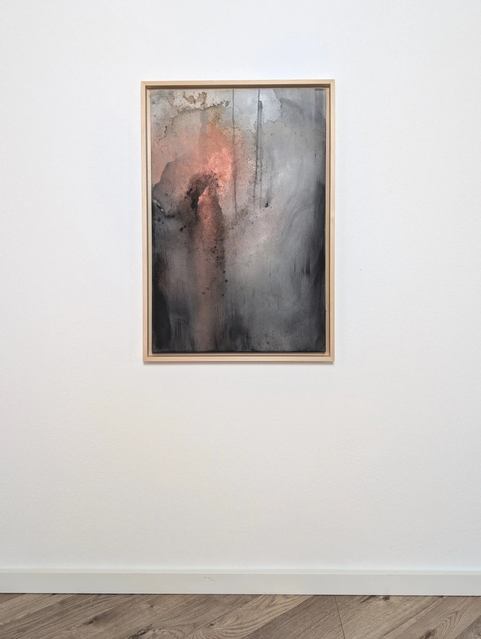 Ein modernes Gemälde mit abstrakten Mustern in Erdtönen, umrahmt von einem einfachen Holzrahmen, hängt an einer weißen Wand in einem Kunstgalerie-Raum.