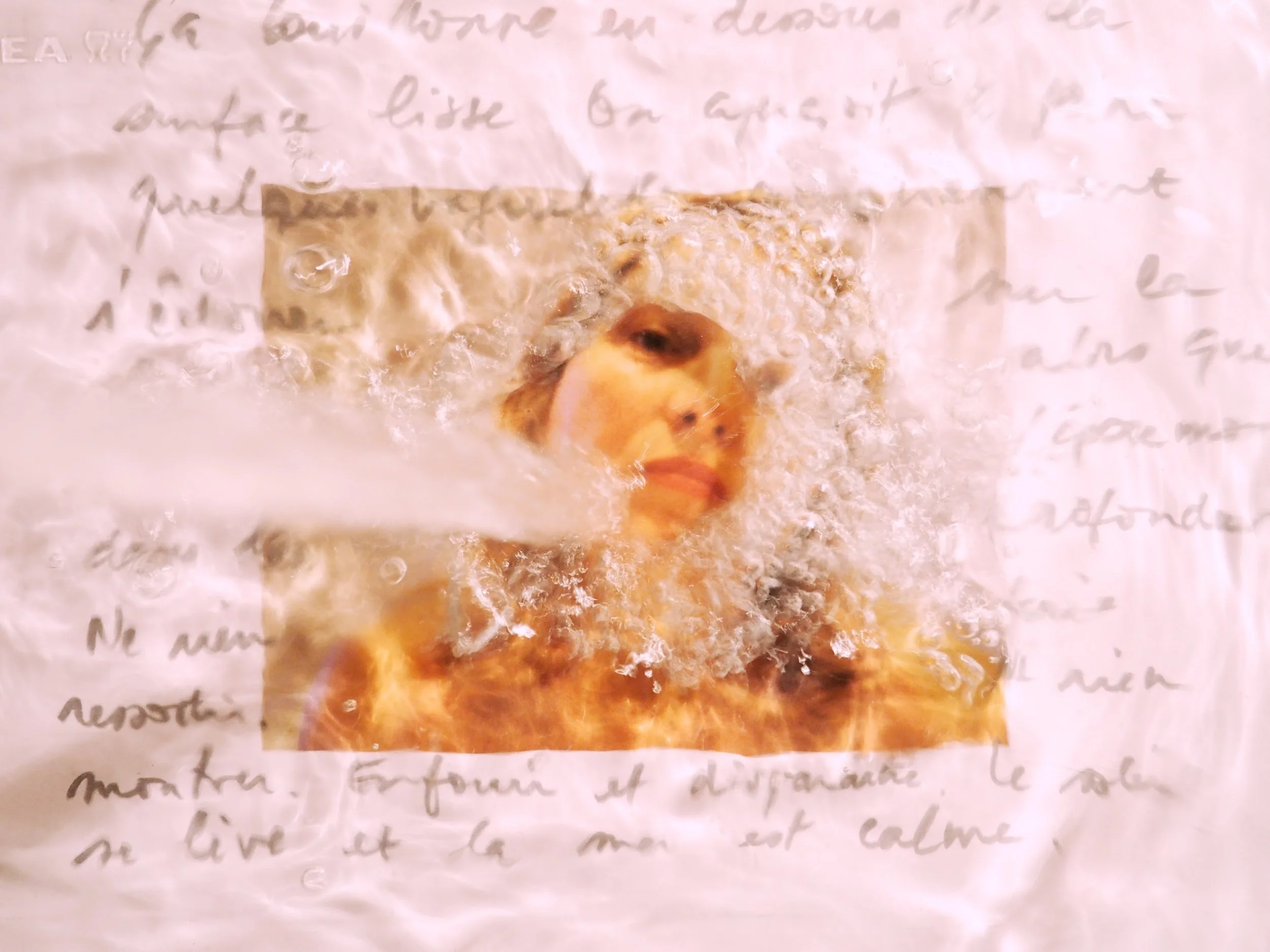 Une photo floue d'une feuille manuscrite avec une image partielle d'une femme, placée sur la page, avec un texte écrit derrière.