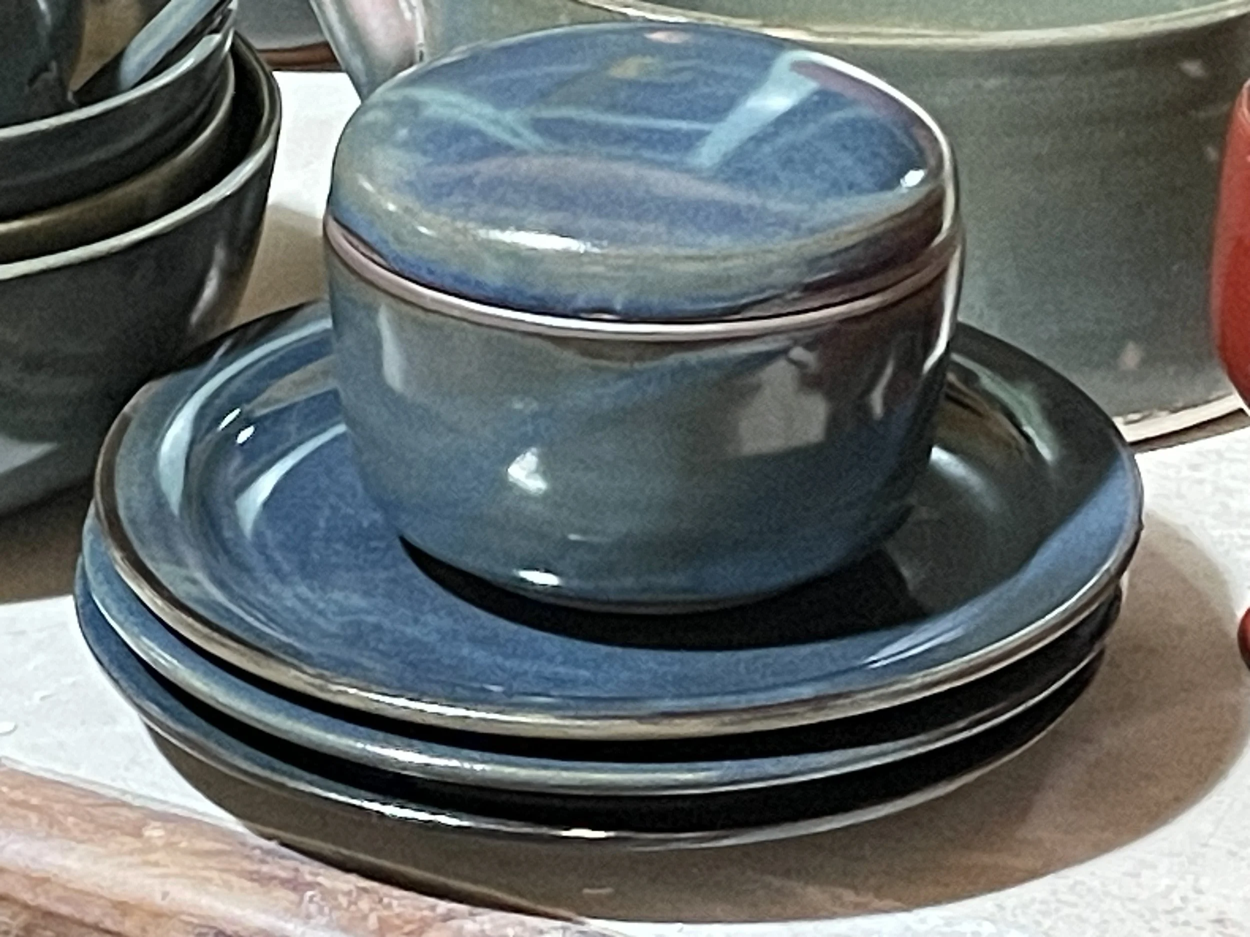 A stack of blue ceramic plates on a white surface.