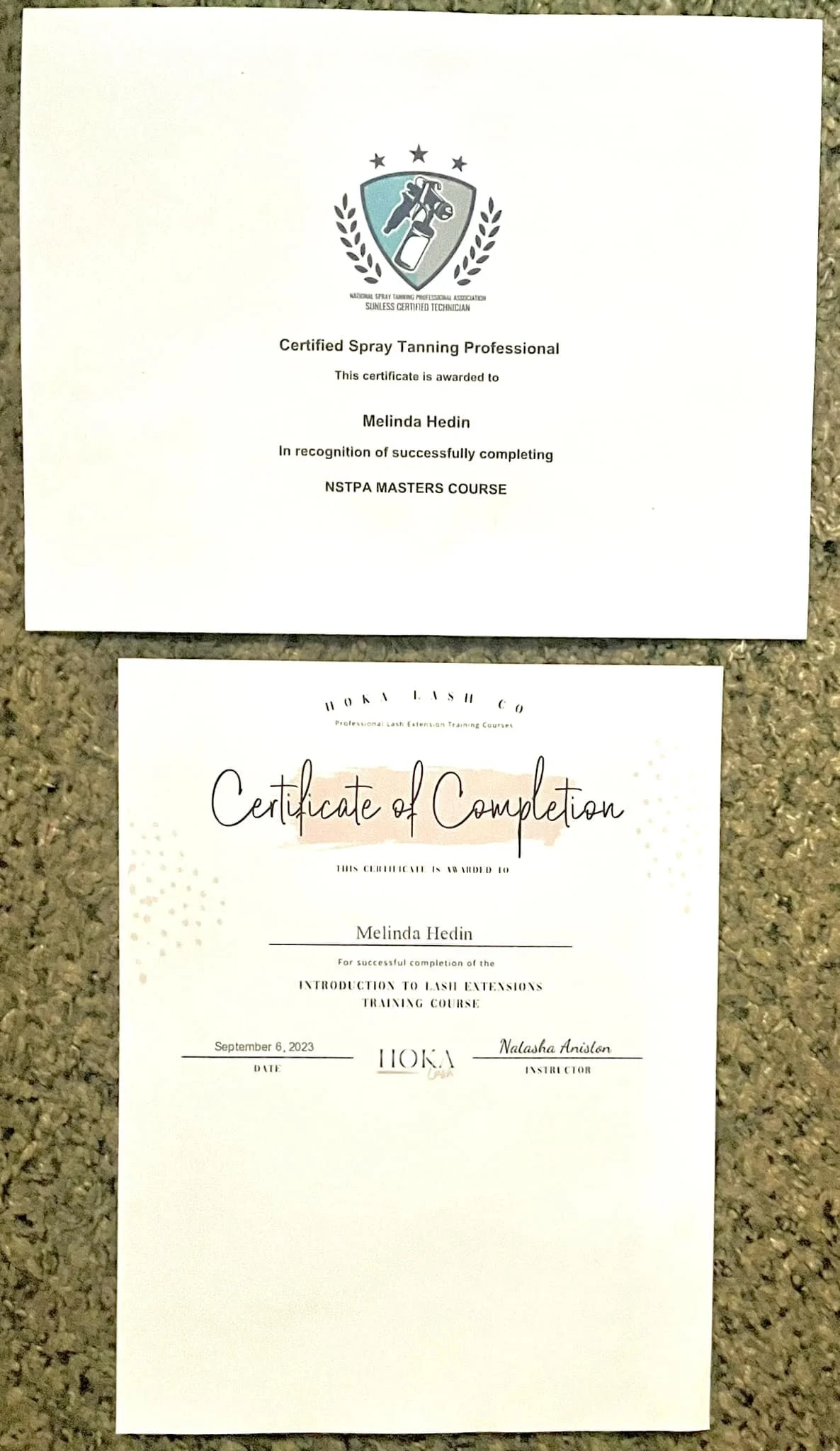 A certificate of completion for a Lash Extensions training course awarded to Melinda Hedin, dated September 6, 2023, with a second certificate from the National Spray Tanning Professional Association for a spray tanning course also awarded to Melinda