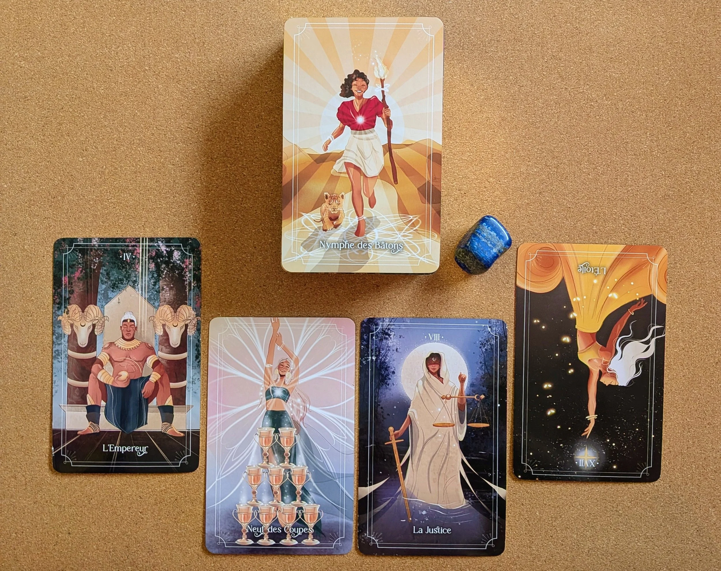 Tarot card titled 'Nymphe des Bâtons' depicting a smiling woman with curly hair, holding a torch, with a lion cub at her feet, set against a radiant background.