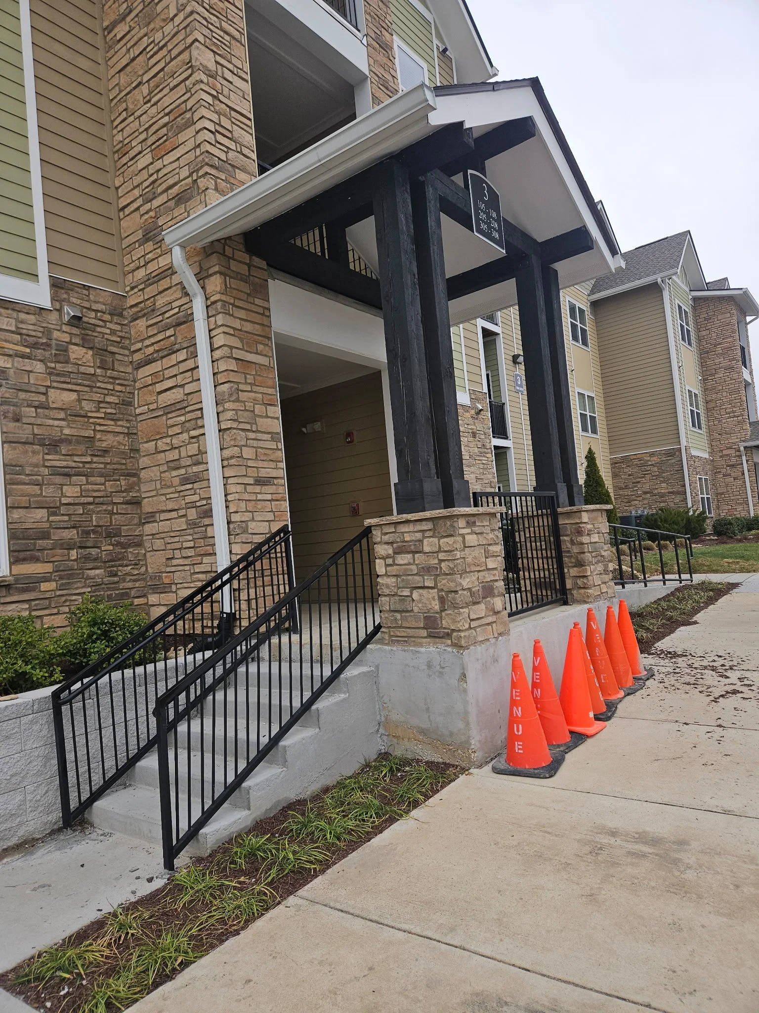Custom structural steel entryway awning frame and matching commercial handrail system. Precision-fabricated with heavy-duty black steel posts to deliver an industrial, modern aesthetic with lasting structural integrity.